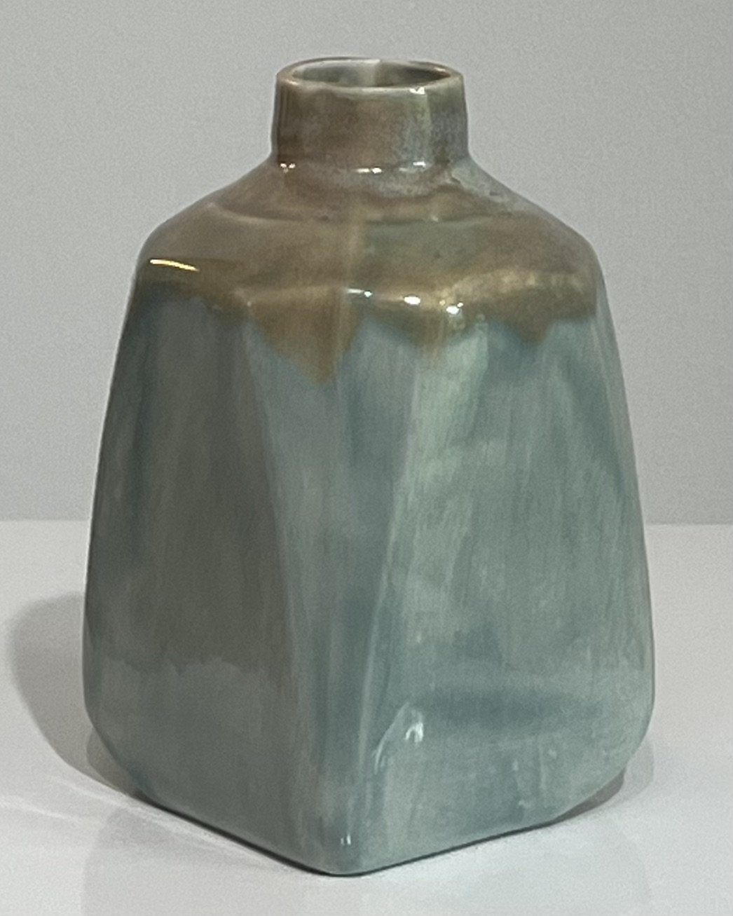 Back view of a one-of-a-kind porcelain milk jug with atmospheric blue-green ceramic glaze.