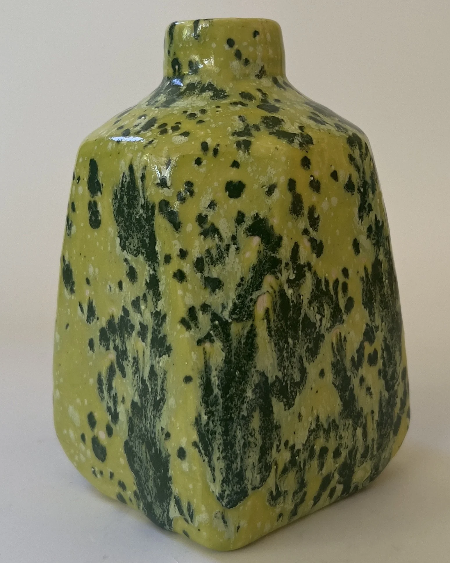Back view of handmade ceramic jug with layered lime and black speckled glaze