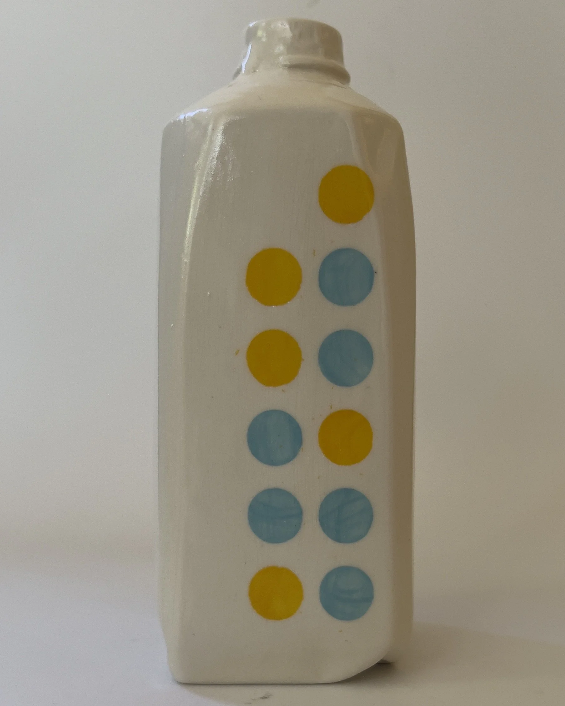 Front view of handmade ceramic tall jug with yellow and jade blue dot pattern