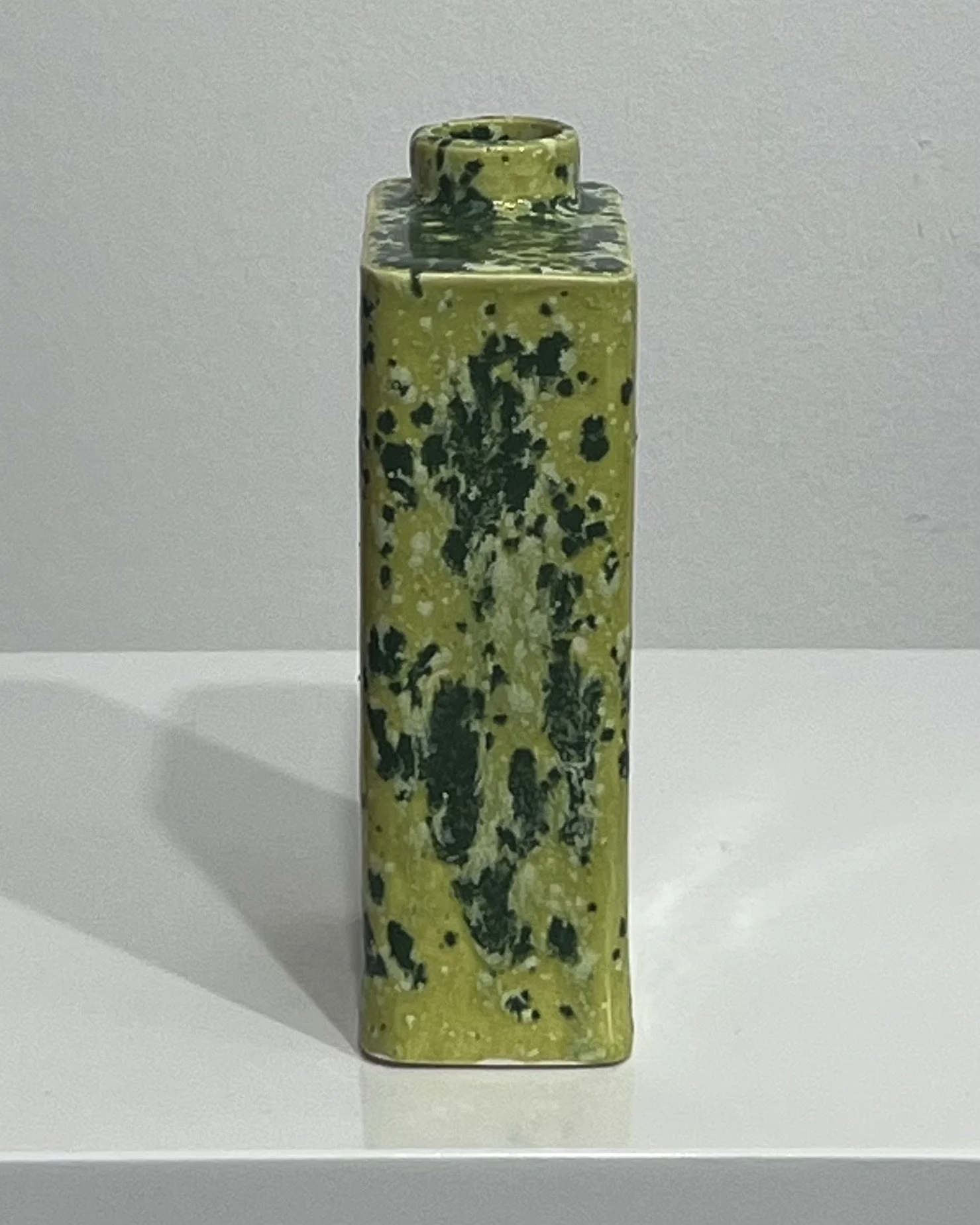 Side view of one-of-a-kind Lime Shower porcelain carton with vibrant green glazing