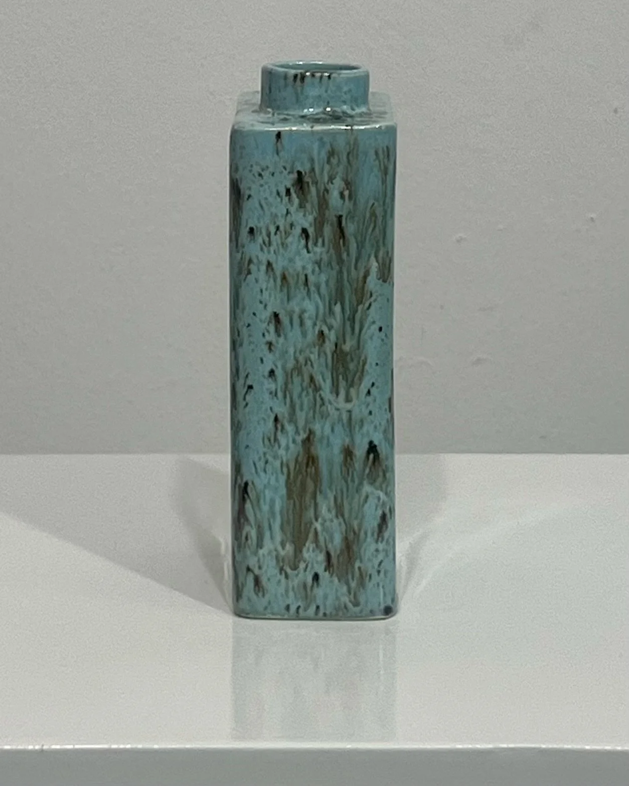 Side profile of handmade porcelain carton vase in glossy Cenote glaze.