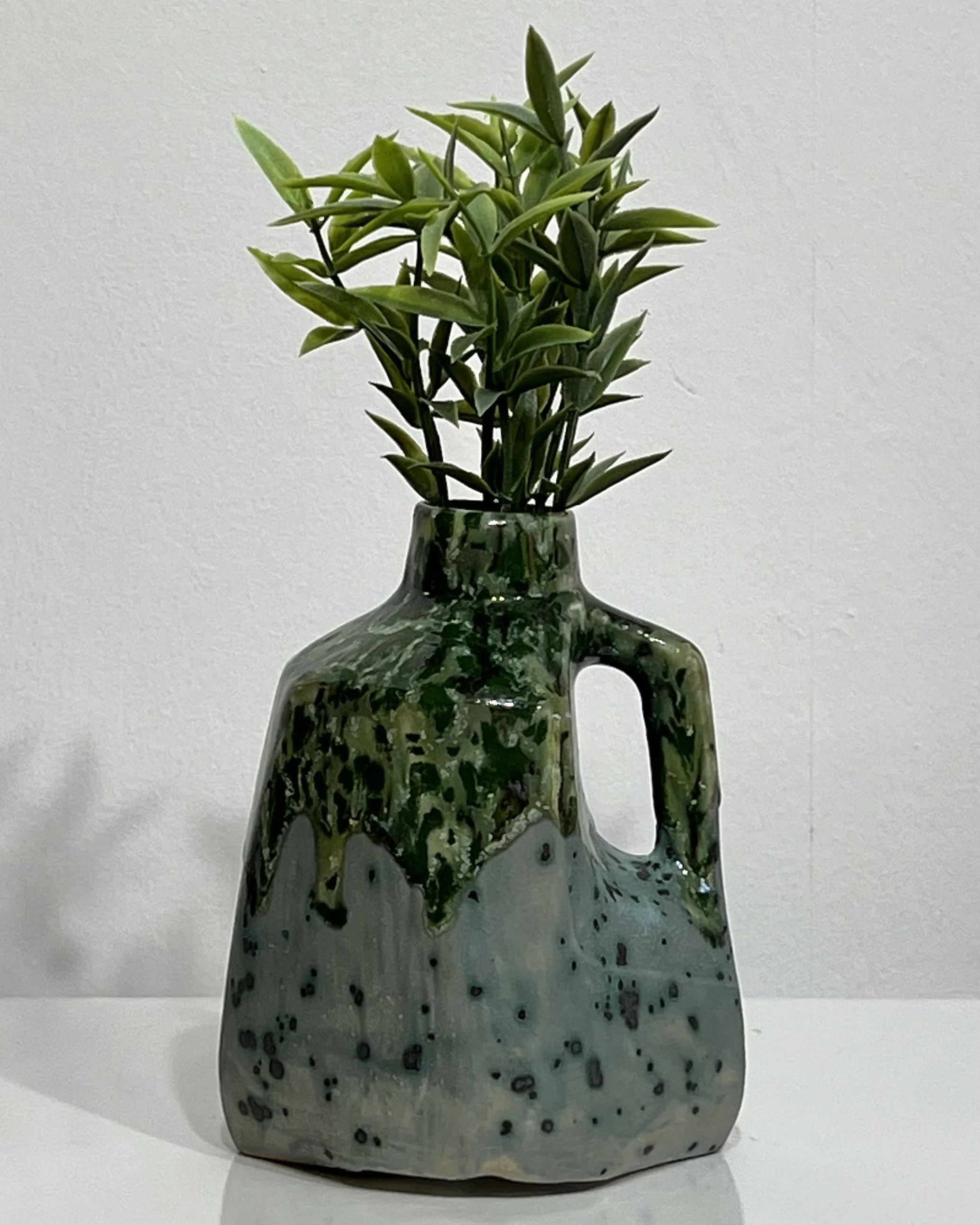 Handmade porcelain milk jug vase 26.122 by Alissa Van Atta, featuring glossy green Lime Shower glaze over speckled Moonscape glaze, styled with greenery.