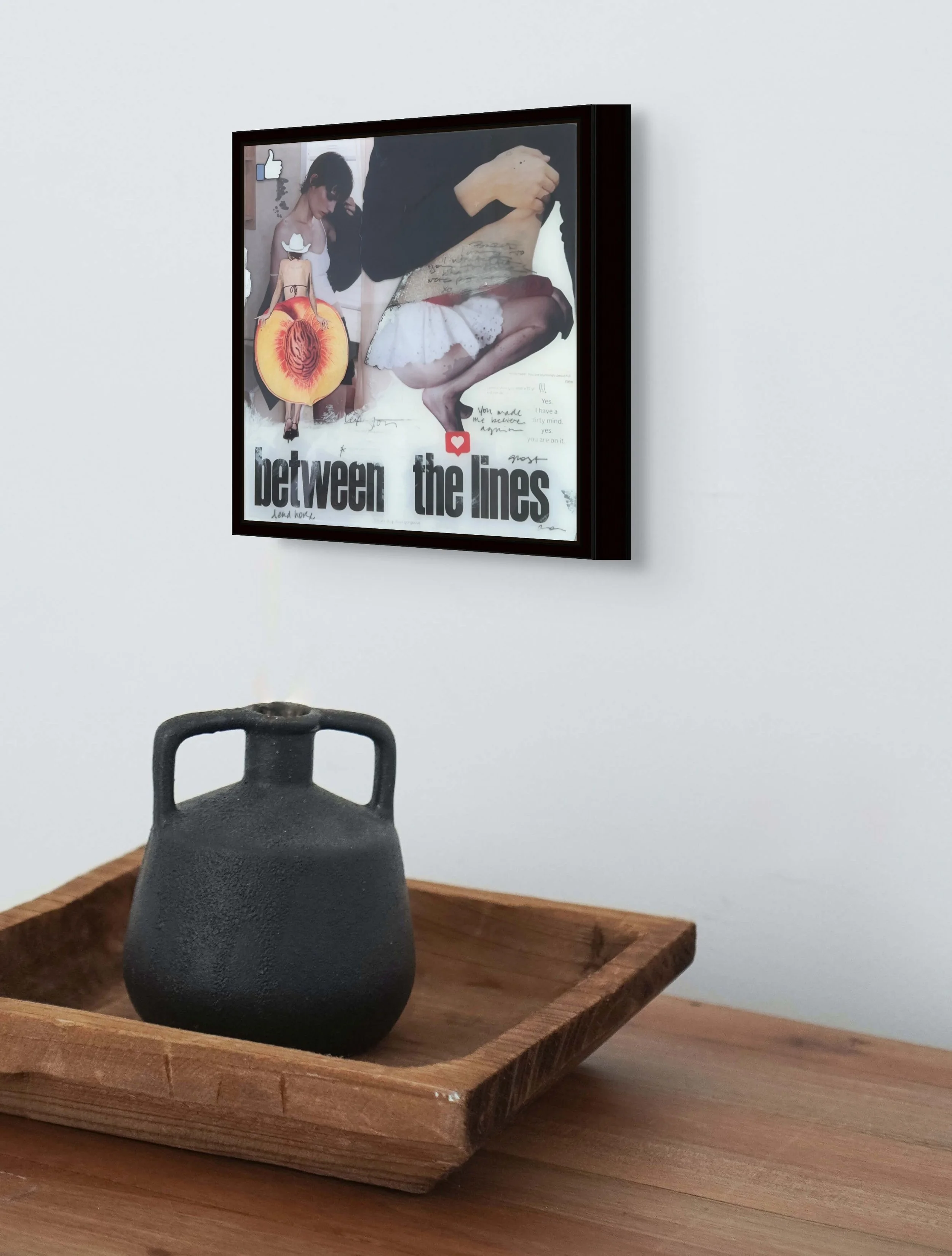 Framed contemporary feminist collage artwork by Alissa Van Atta displayed above books and a kettle in a modern interior setting.