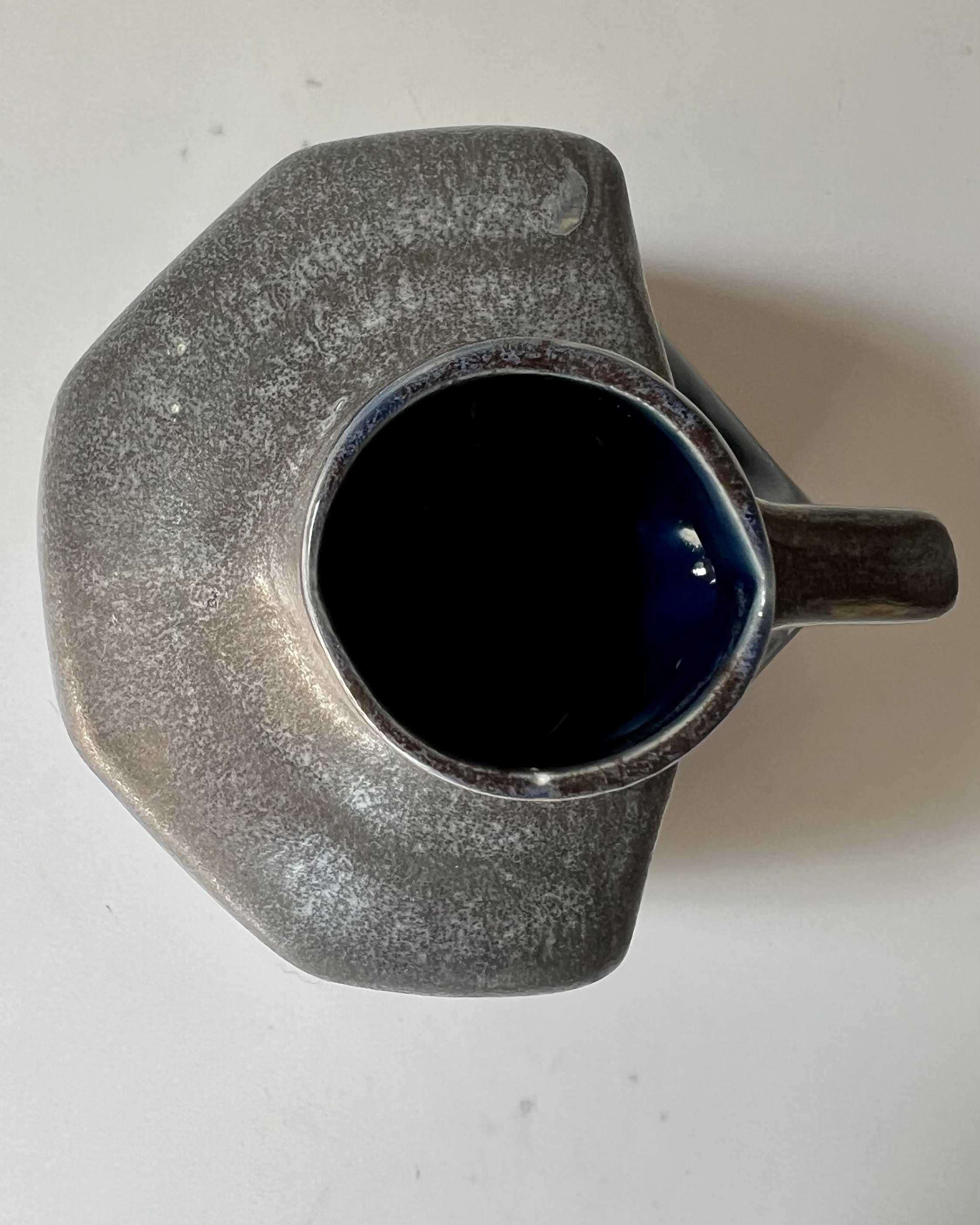 Top view of a handmade porcelain milk jug showing the opening and interior.