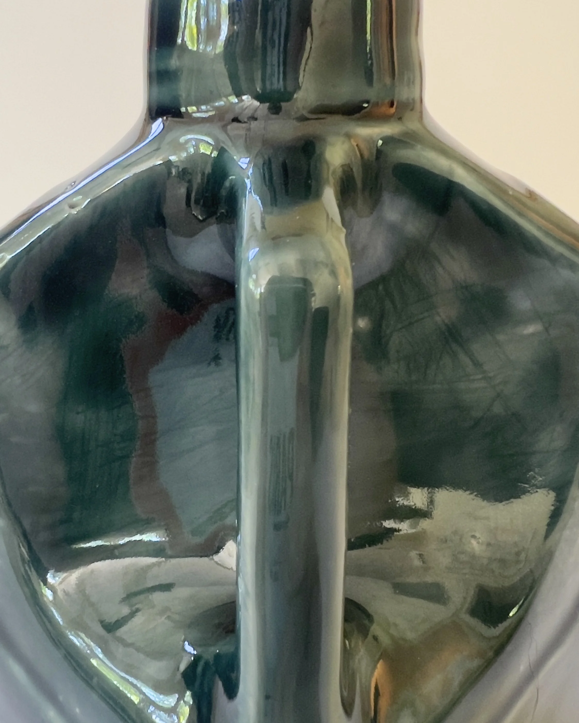 Detail view of handmade ceramic jug showing glossy layered glaze texture