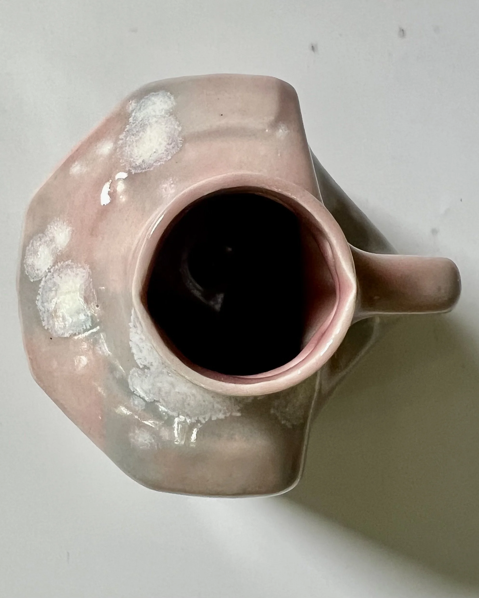 Top opening of porcelain milk jug showing functional vase interior.