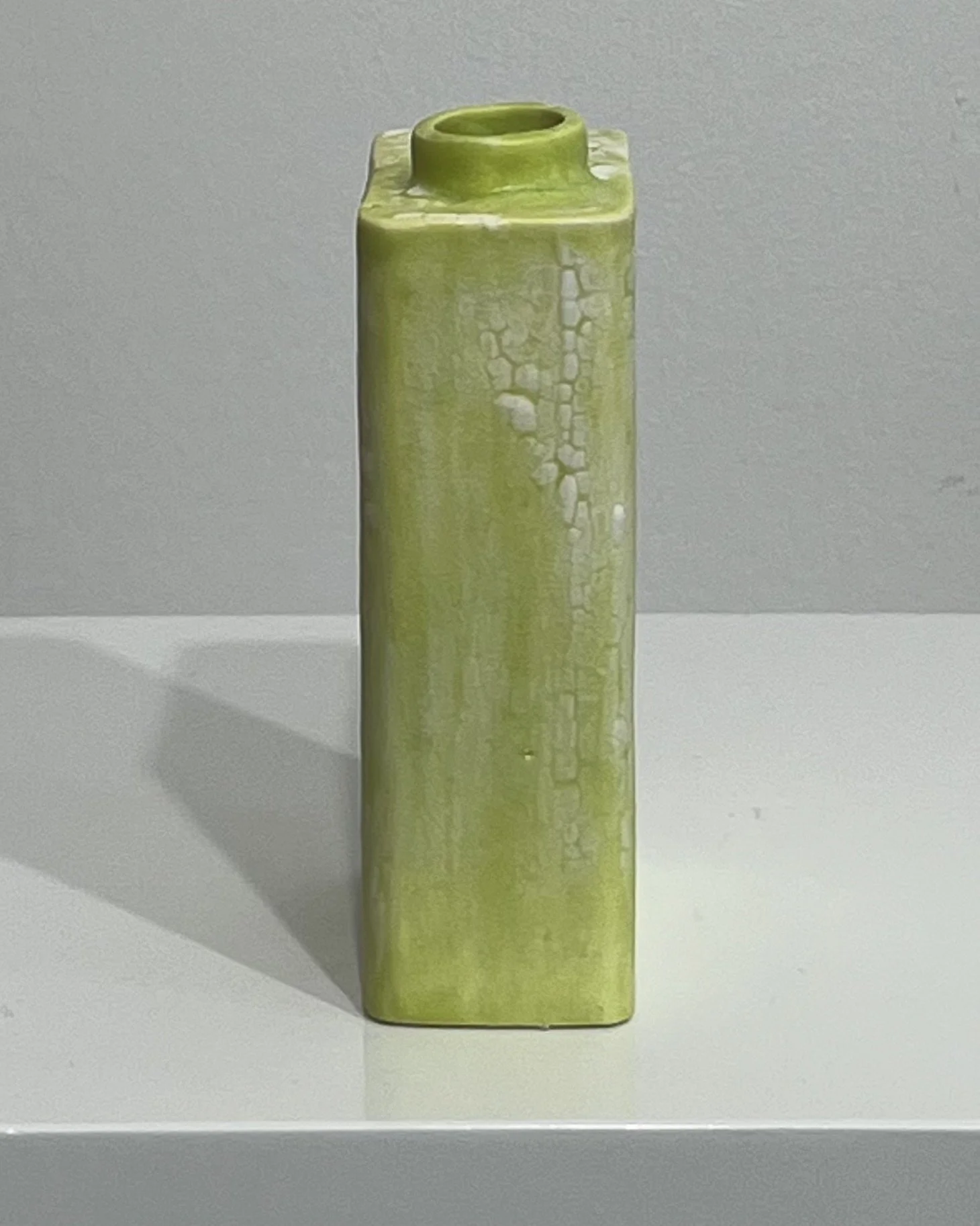 Left-side profile of slim, angular porcelain Carton vessel with mottled chartreuse glaze.