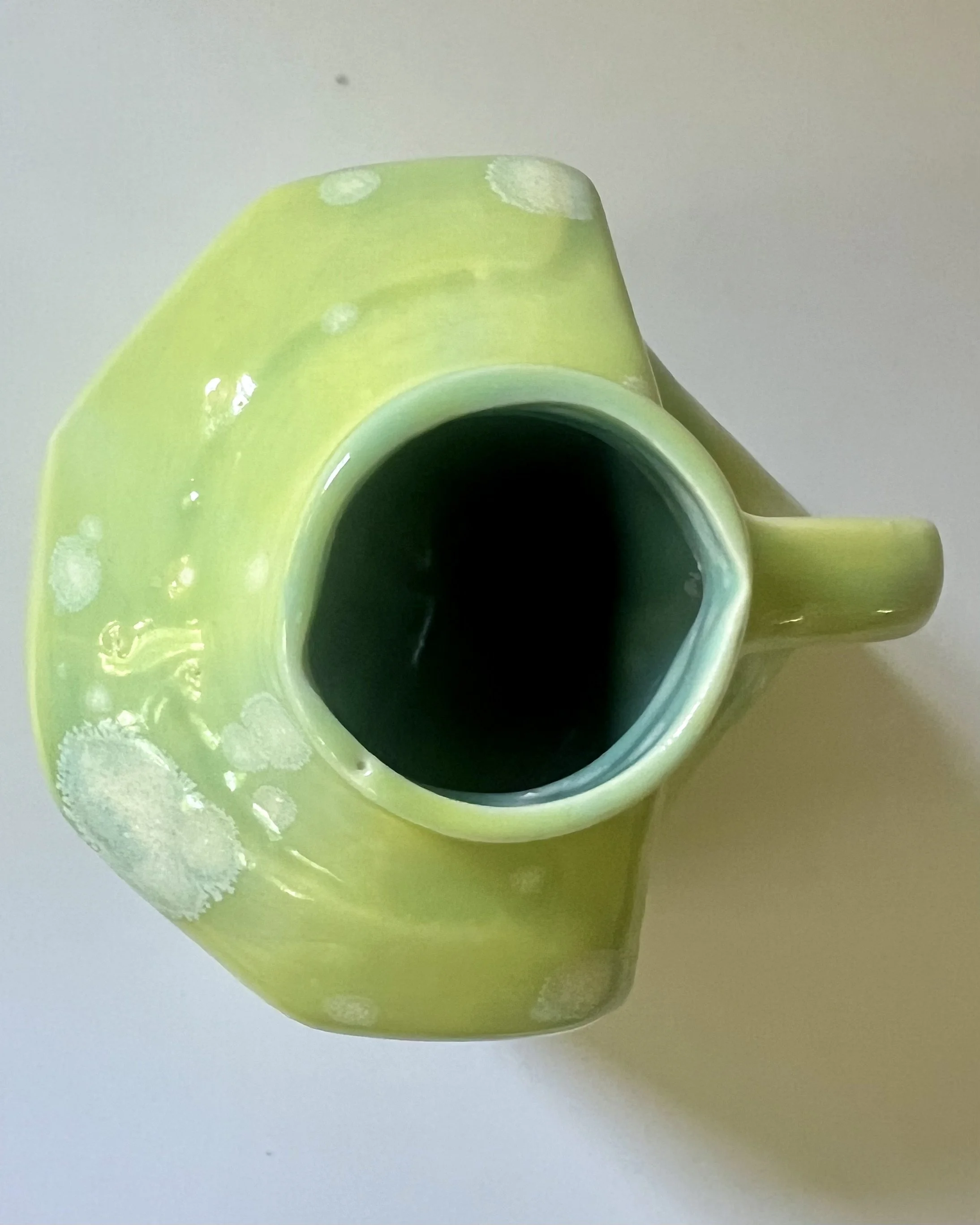 Top view of porcelain milk jug showing glazed interior and vessel opening.