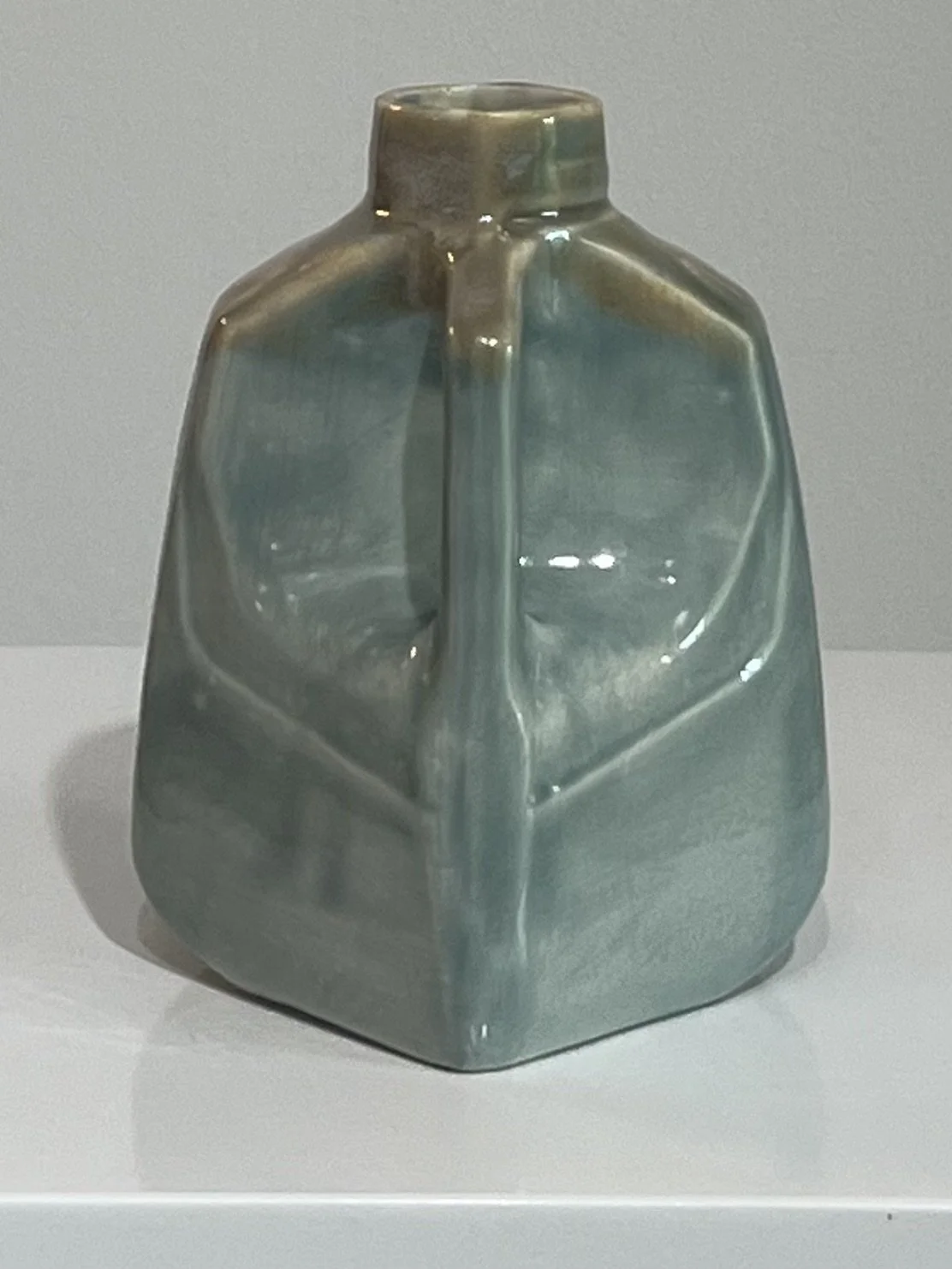 Side view of a contemporary porcelain milk jug featuring flowing White Satin Matte and Mystic Tide glazes.
