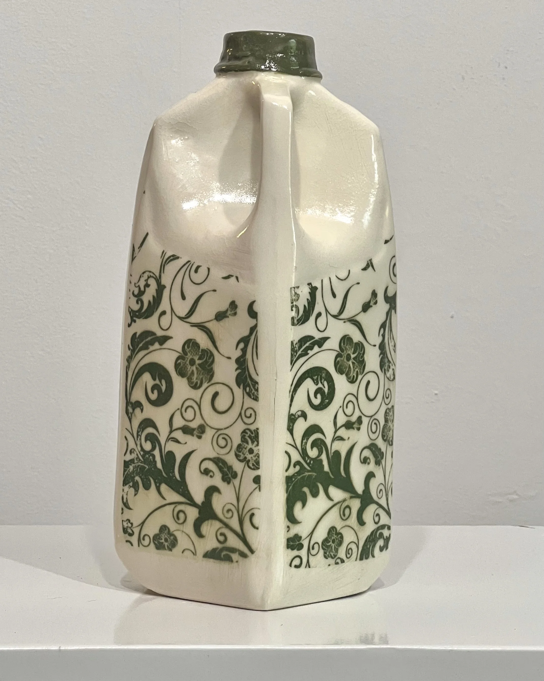 Right side view of a botanical tall porcelain milk jug with glossy clear glaze and illustrated botanical transfer.