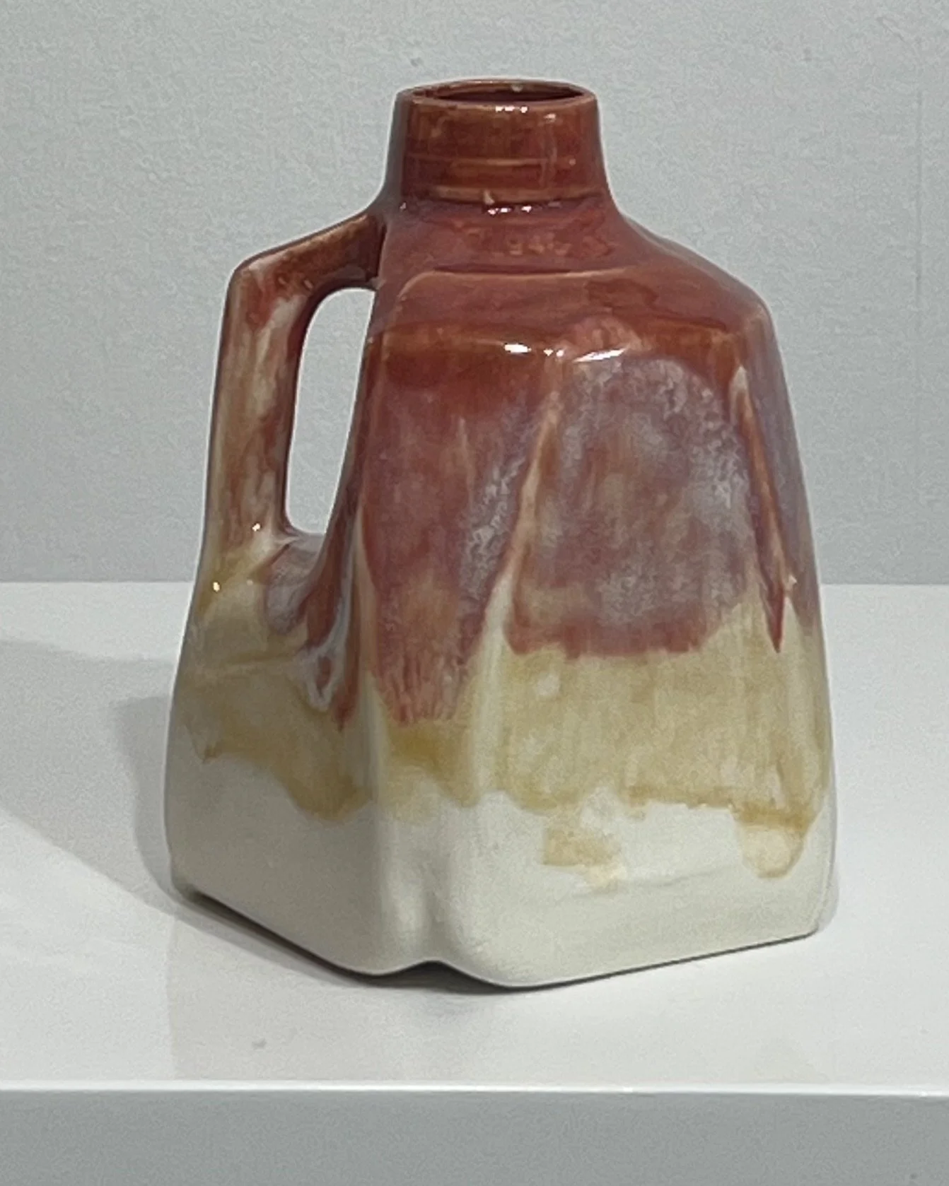 Rear view of a one-of-a-kind porcelain milk jug with rich plum and cream glaze variations