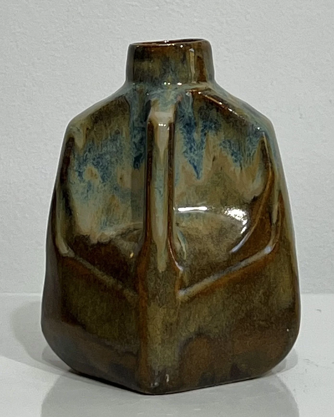 Right-side view of ceramic milk jug 26.124 showing its handle and layered blue and brown glazes