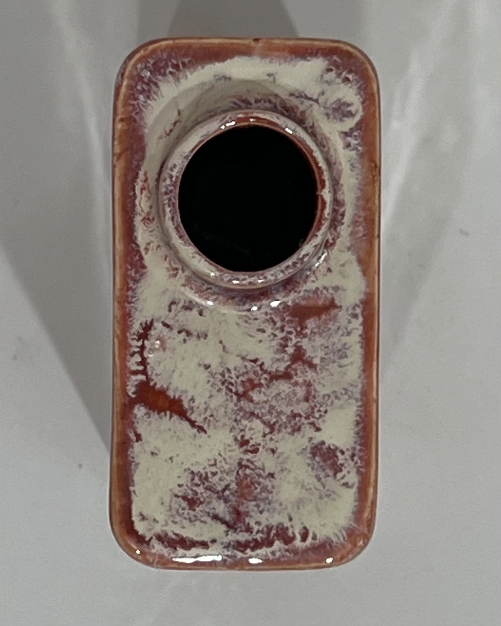 Top view of ceramic carton showing the vessel opening and plum-speckled glazed rim