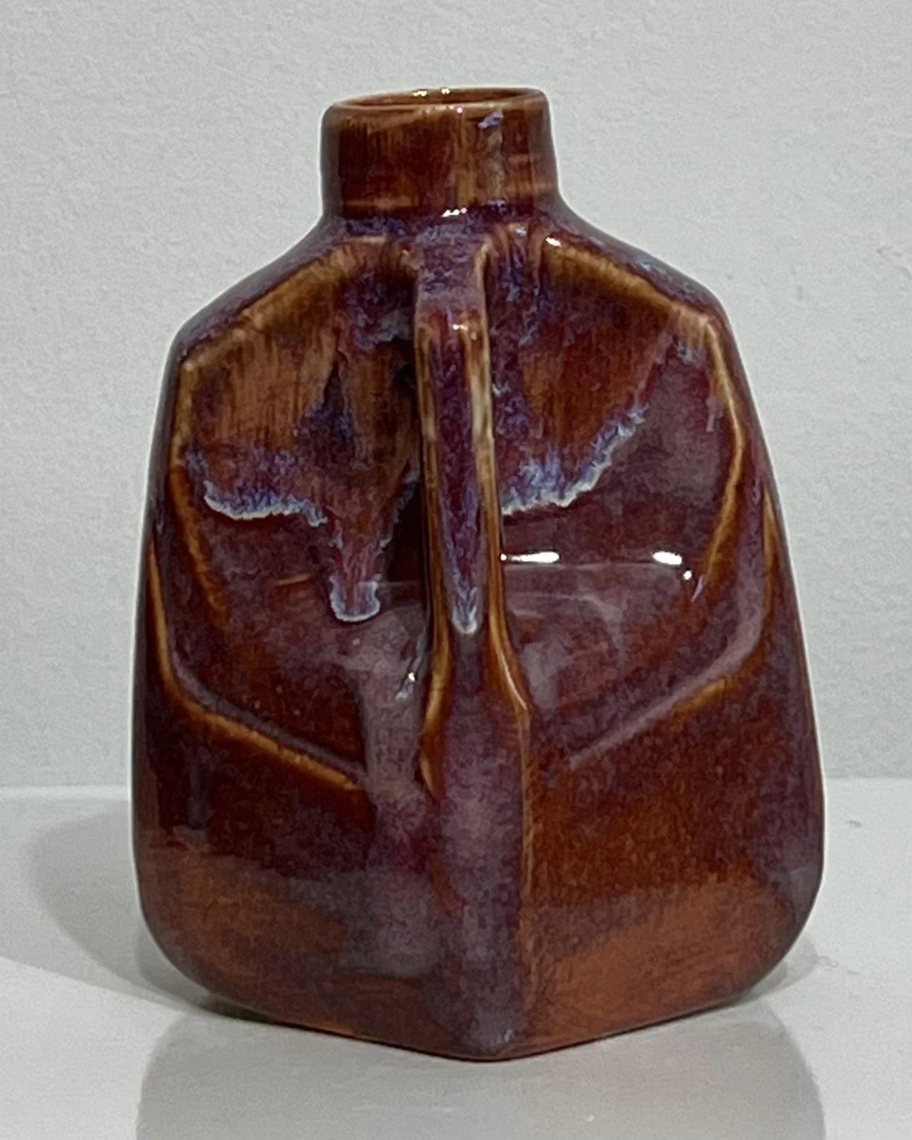 Angled view of handmade Chun Plum and Oatmeal ceramic jug showing sculptural body
