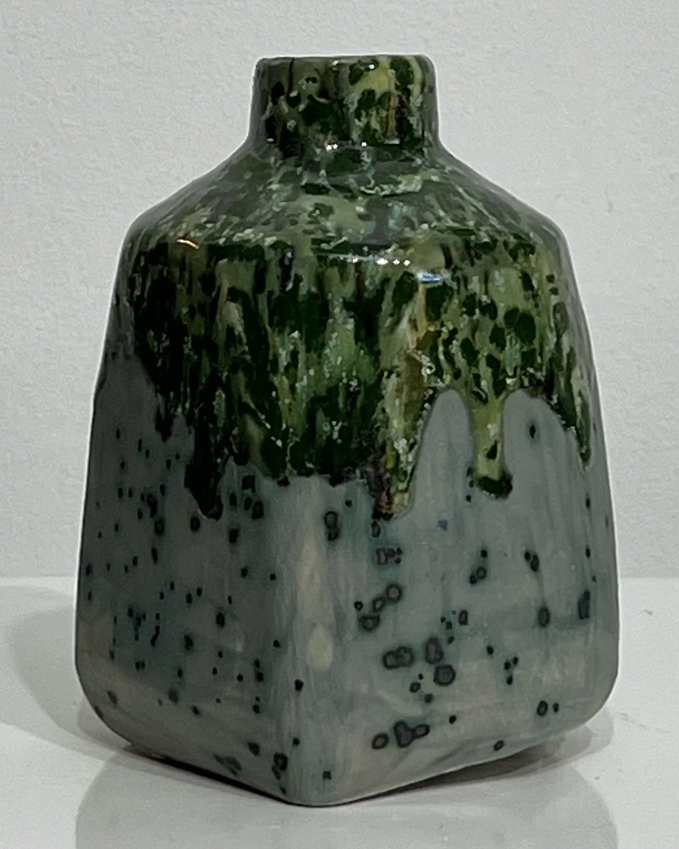 Left-side view of green and speckled handmade milk jug vase