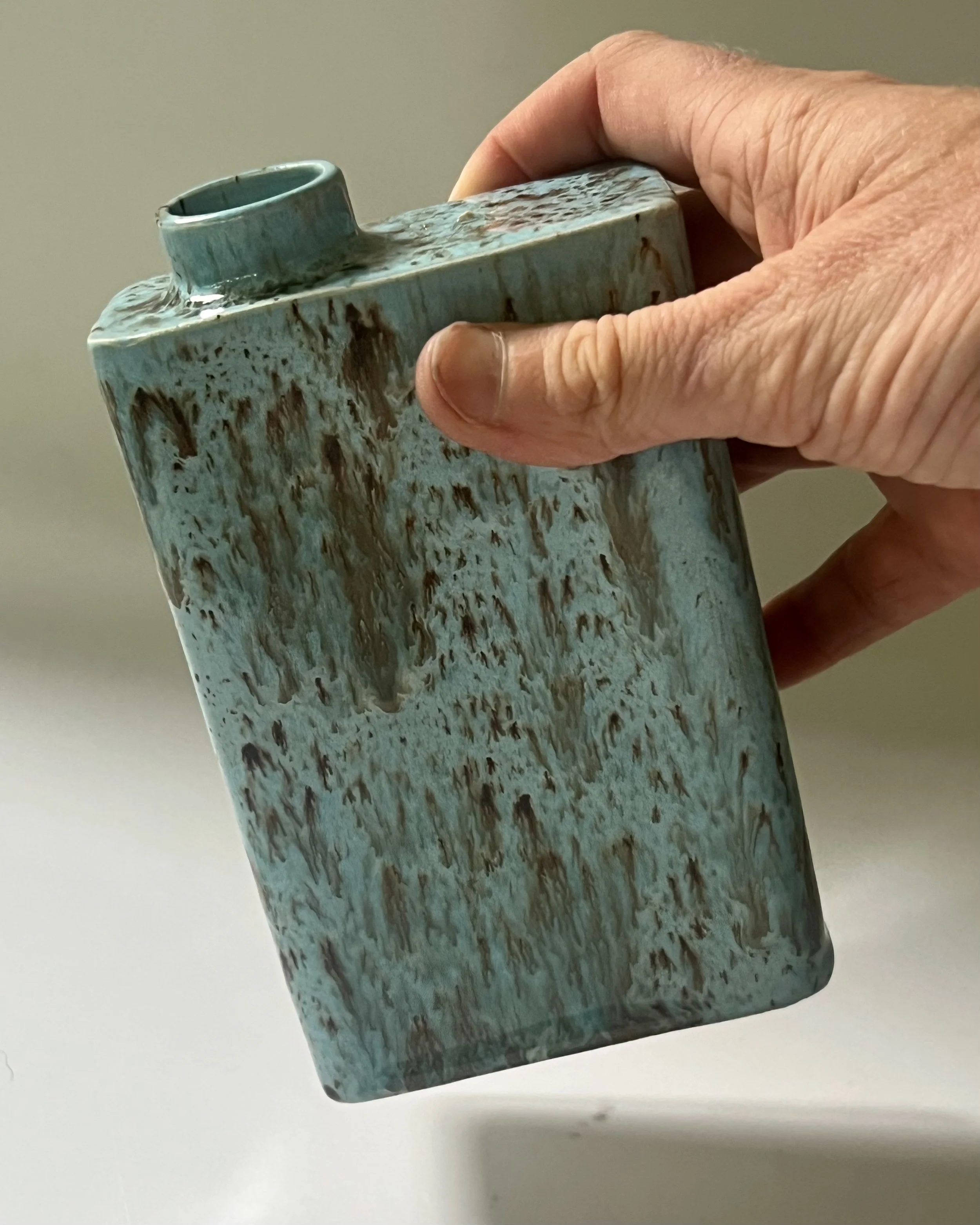 Handmade porcelain carton vase shown in hand for scale, finished in Cenote glaze.