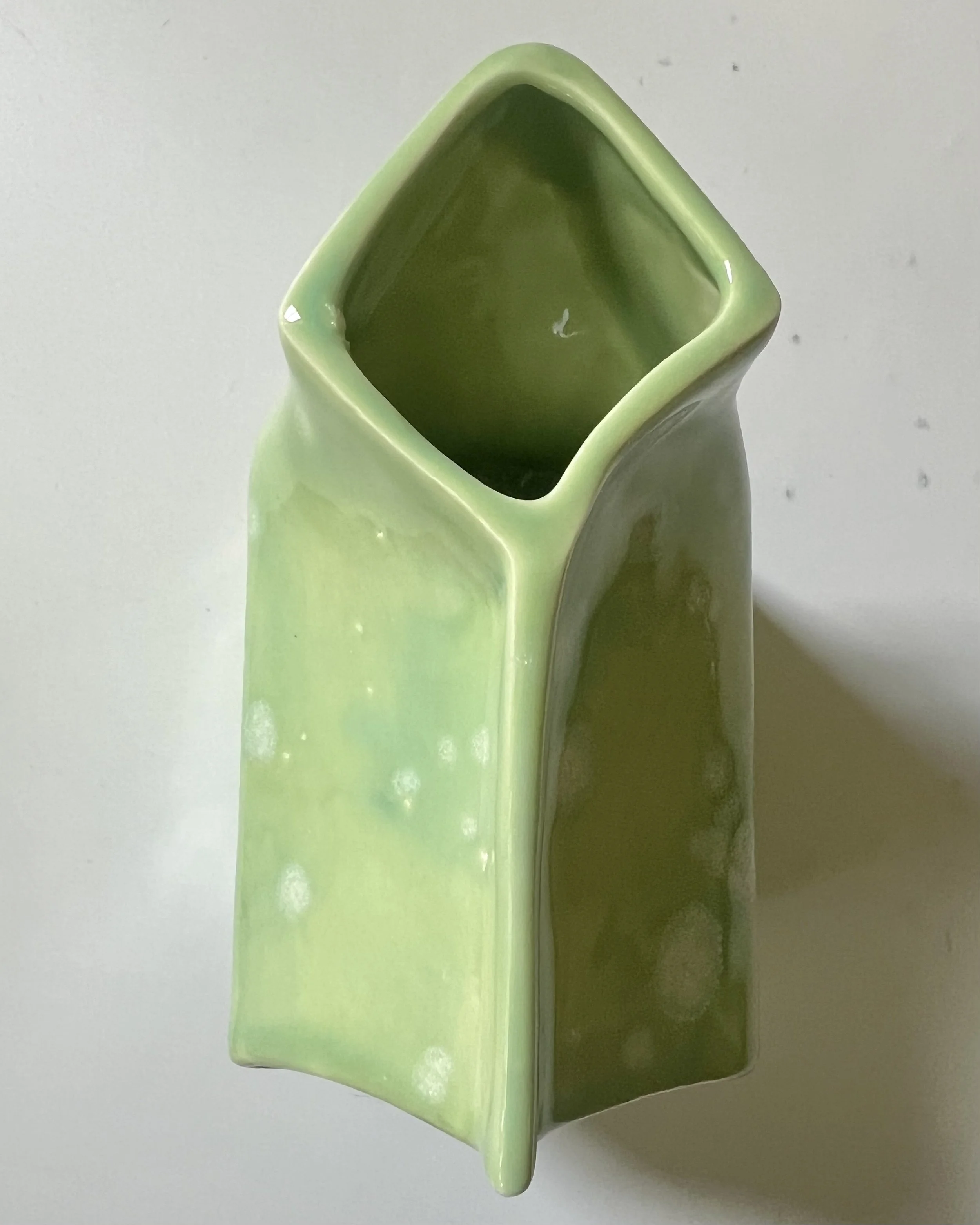 Top opening of porcelain milk carton showing functional vase interior.