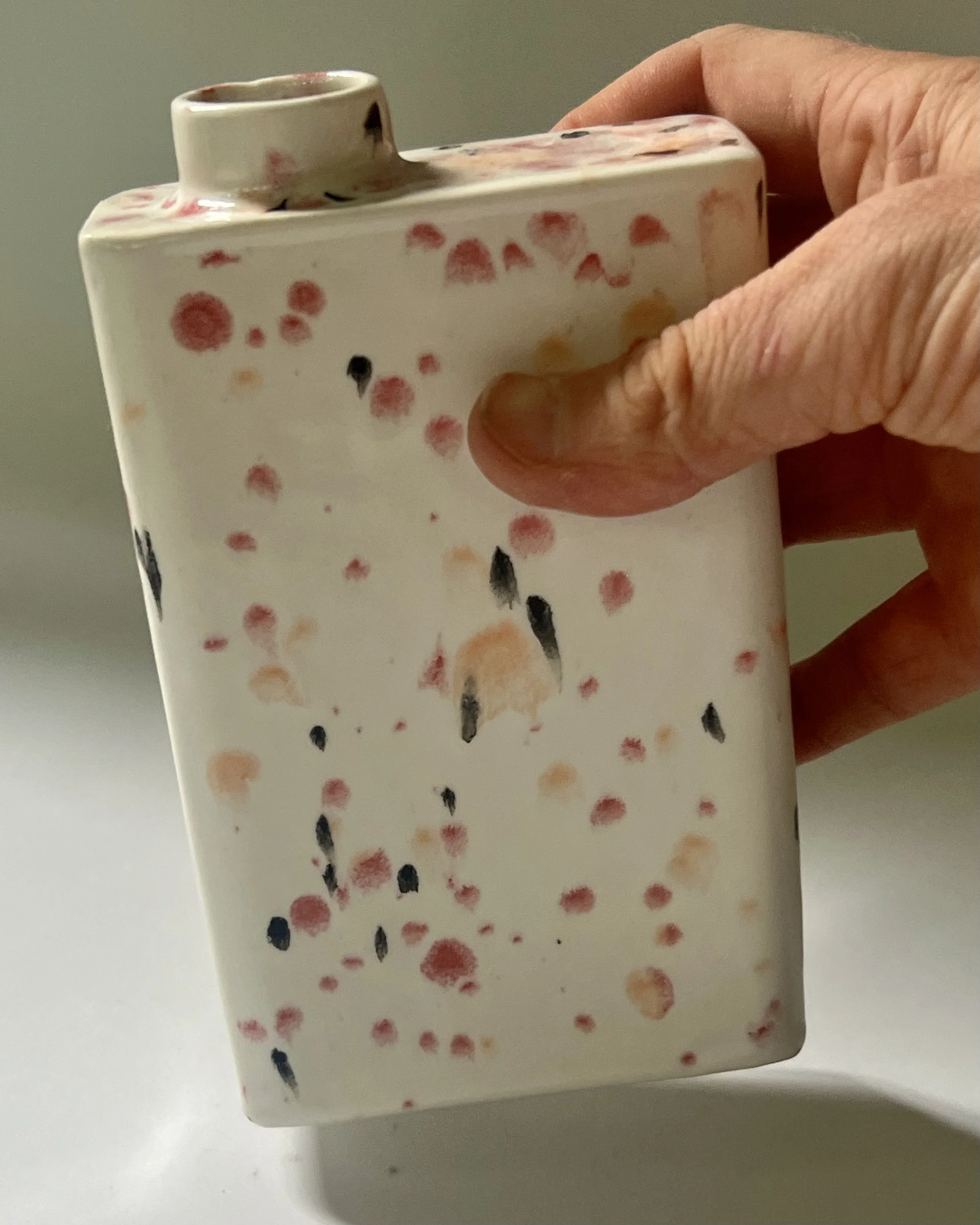 Hand holding Poppy Fields porcelain carton vase C26.6, showing scale and proportions of the porcelain vessel.