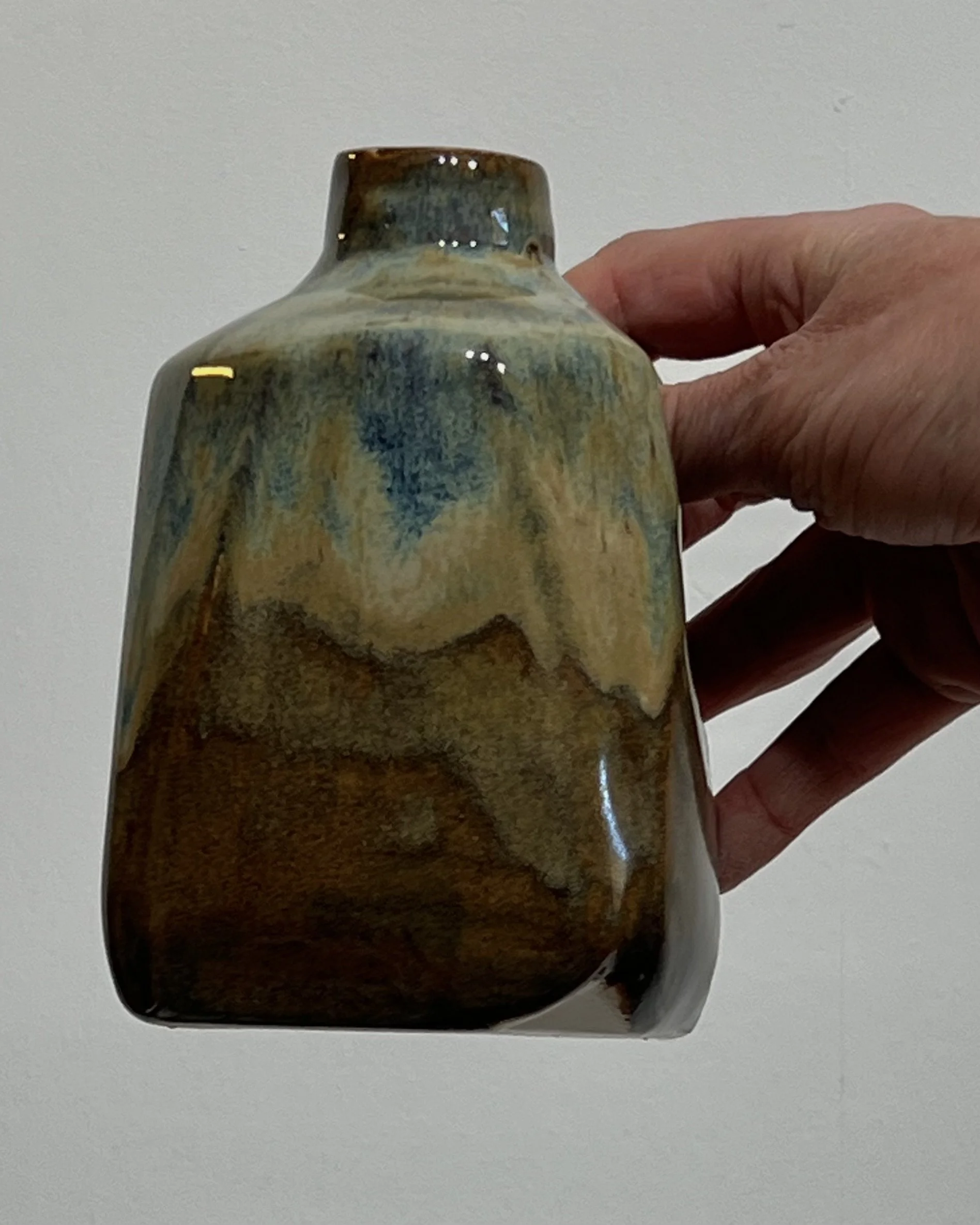 Handmade ceramic milk jug 26.124 held in hand to illustrate its compact size