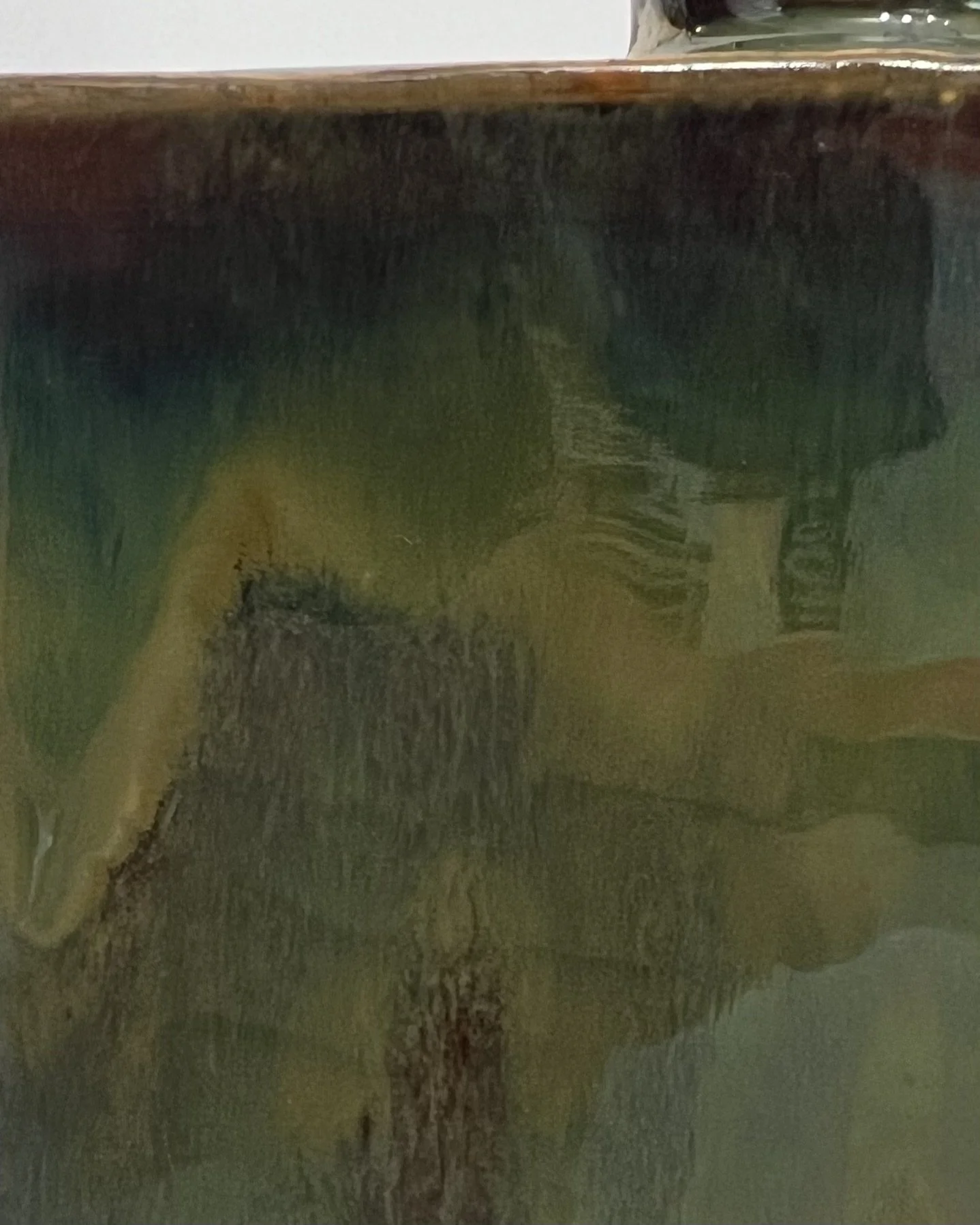 Close-up of olive bronze and charcoal Mood Ring glaze on porcelain