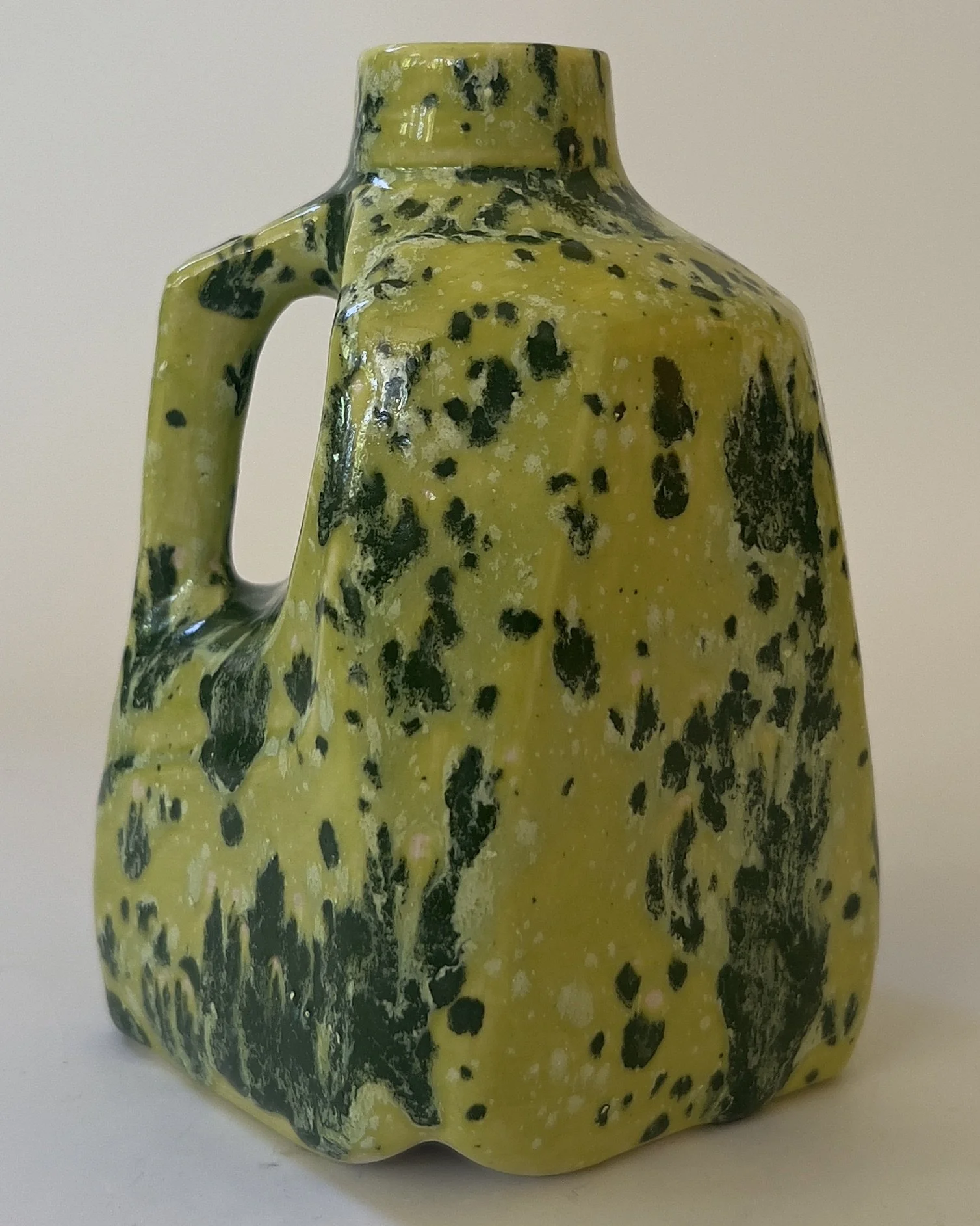 Side angle of sculptural ceramic milk jug with glossy Lime Shower glaze