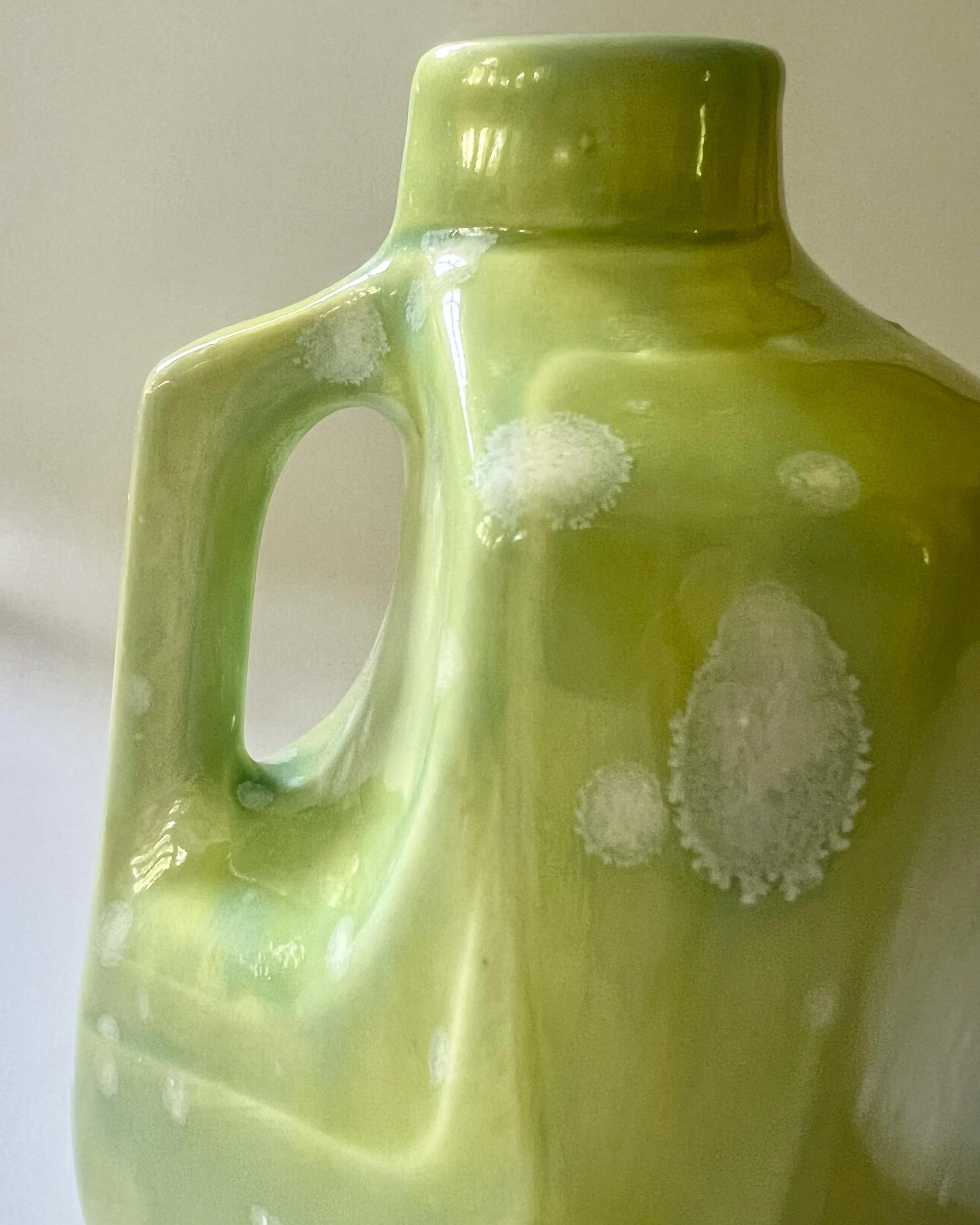 Close-up detail of Celadon Bloom over Pear glaze showing crystalline formations and layered green tones.