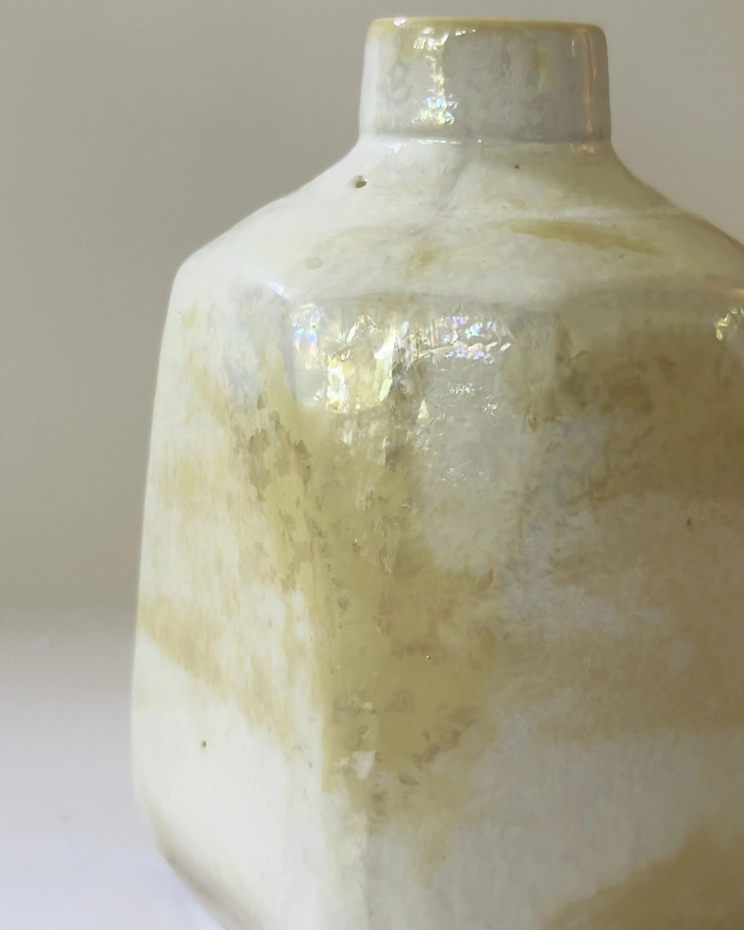 Close-up detail of pearlescent ceramic glaze with soft gold and iridescent textures