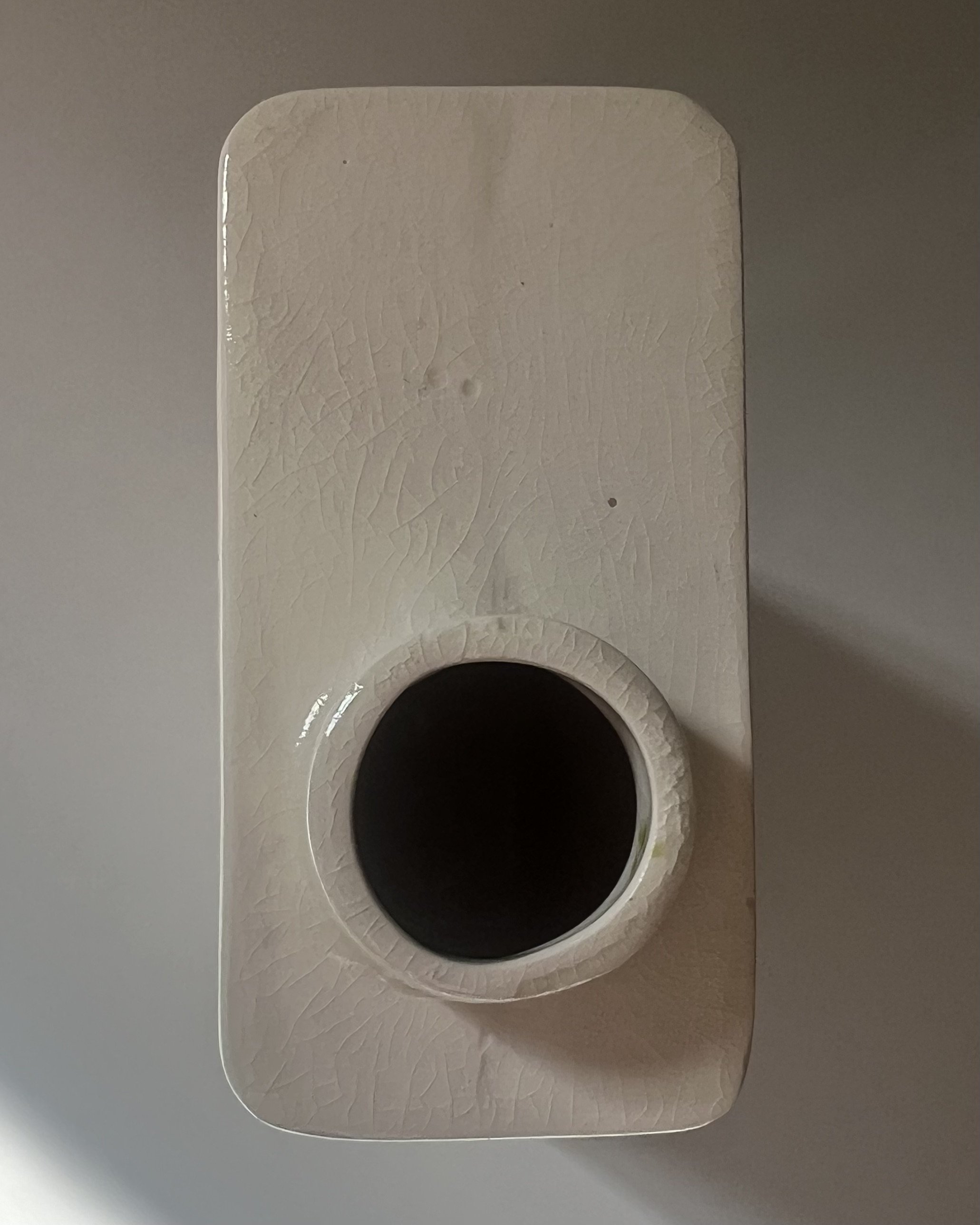 Top view of the opening of a handbuilt porcelain milk carton with glossy glazed interior.