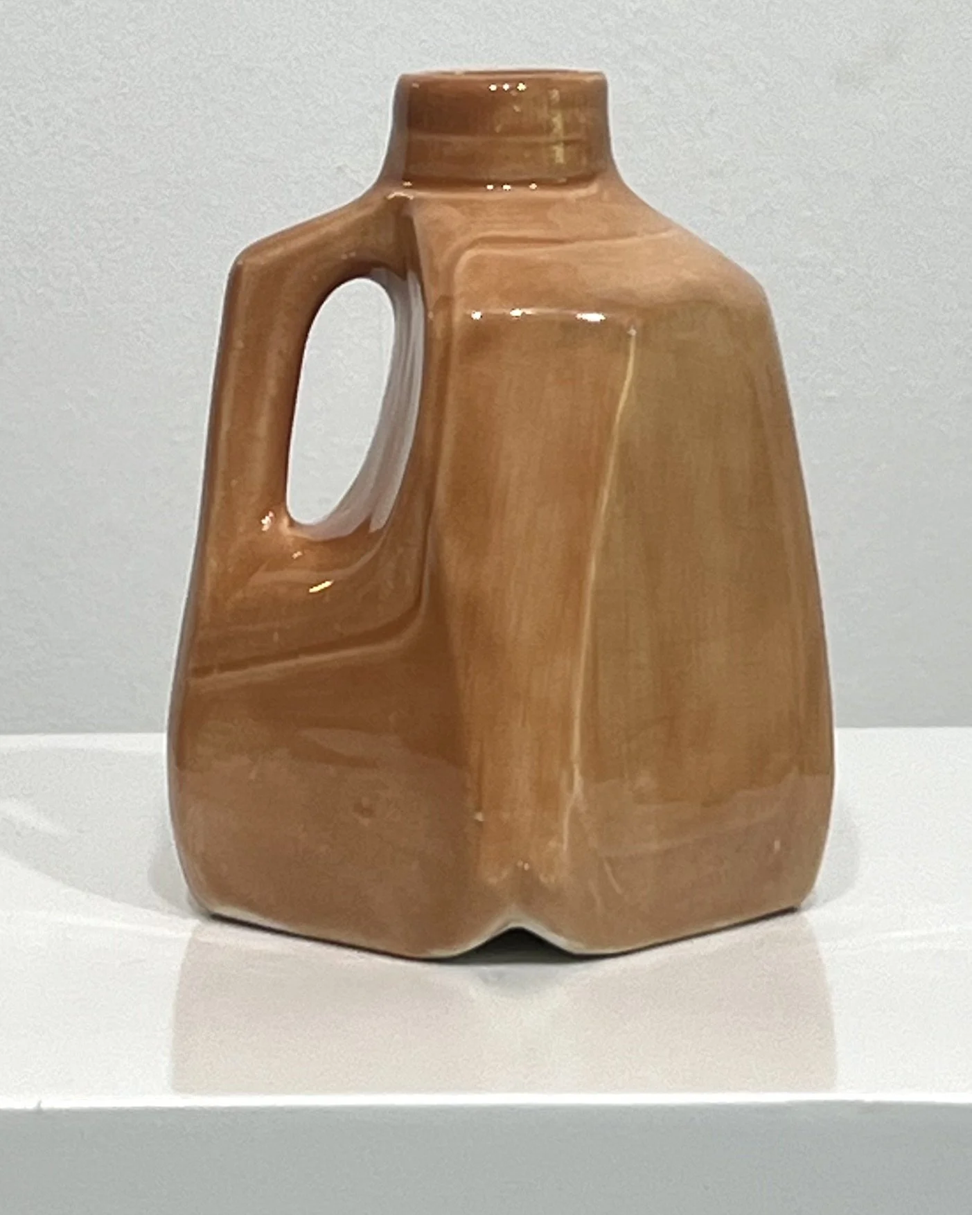 Side view of a porcelain milk jug vase featuring a recessed handle and warm Sandalwood glaze.