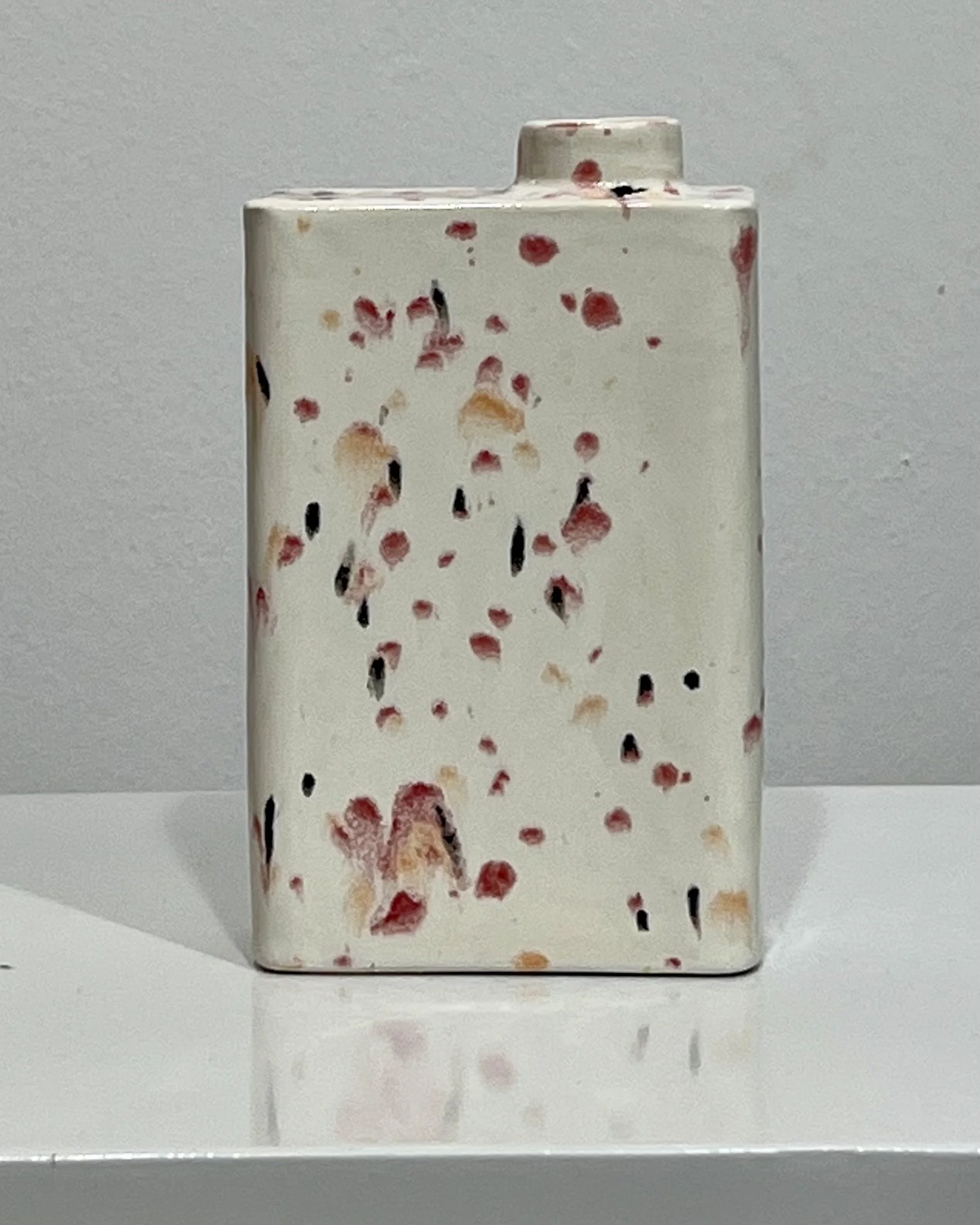 Back view of Poppy Fields porcelain carton vase C26.6 featuring an abstract field of red, peach, and black speckles on cream porcelain.