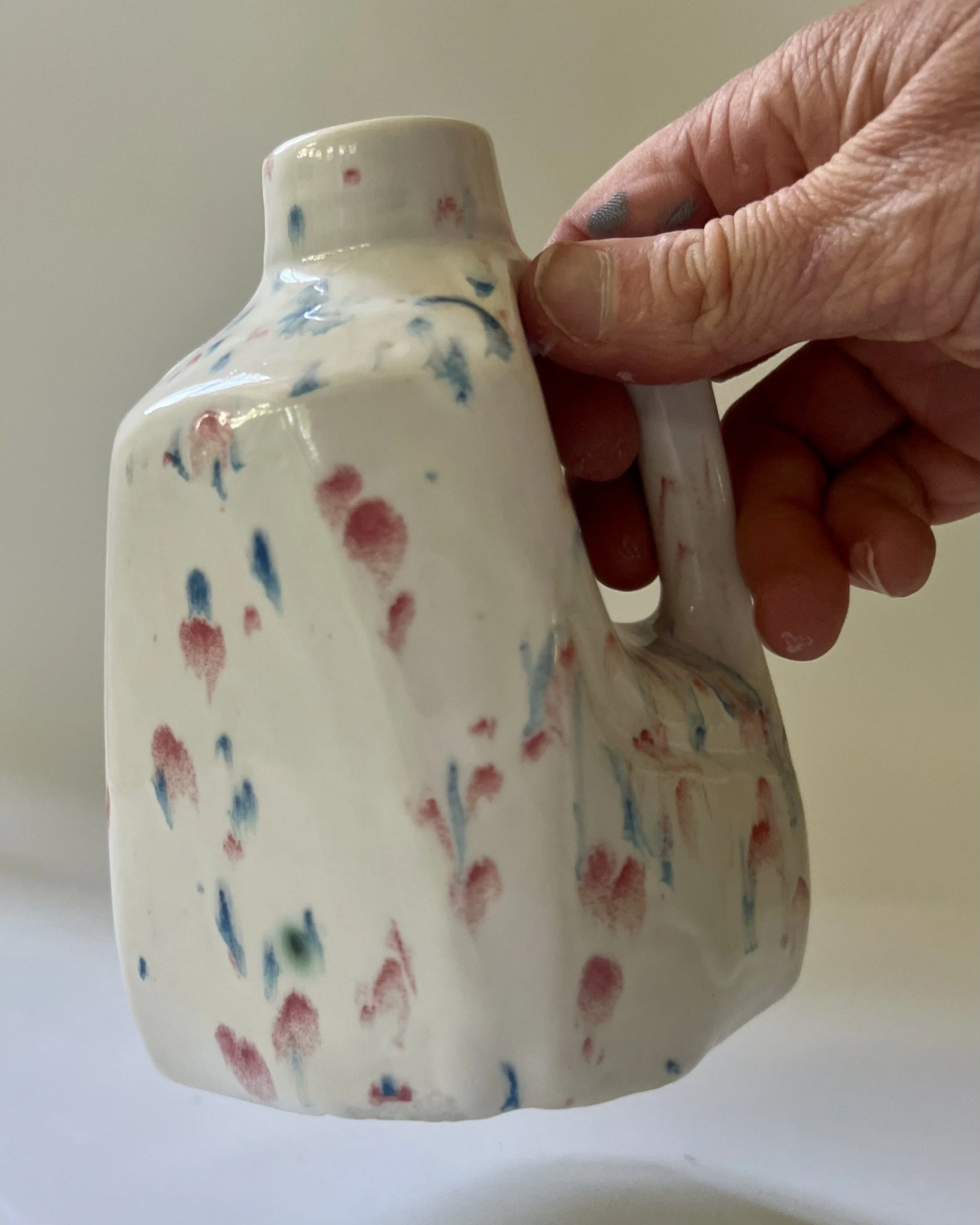 Kaboom porcelain milk jug vase shown in hand for scale, handmade ceramic vessel by Alissa Van Atta.