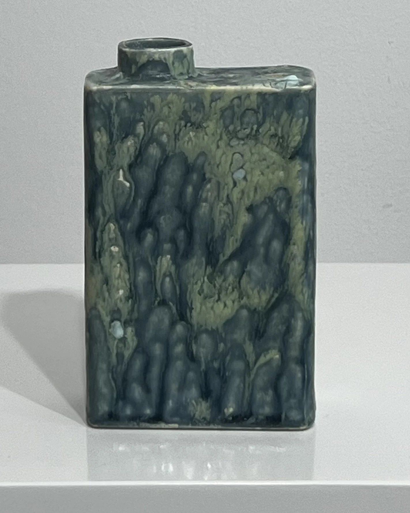 Front view of sculptural porcelain Carton vessel with Satin Oribe and Mudcrack glazes.