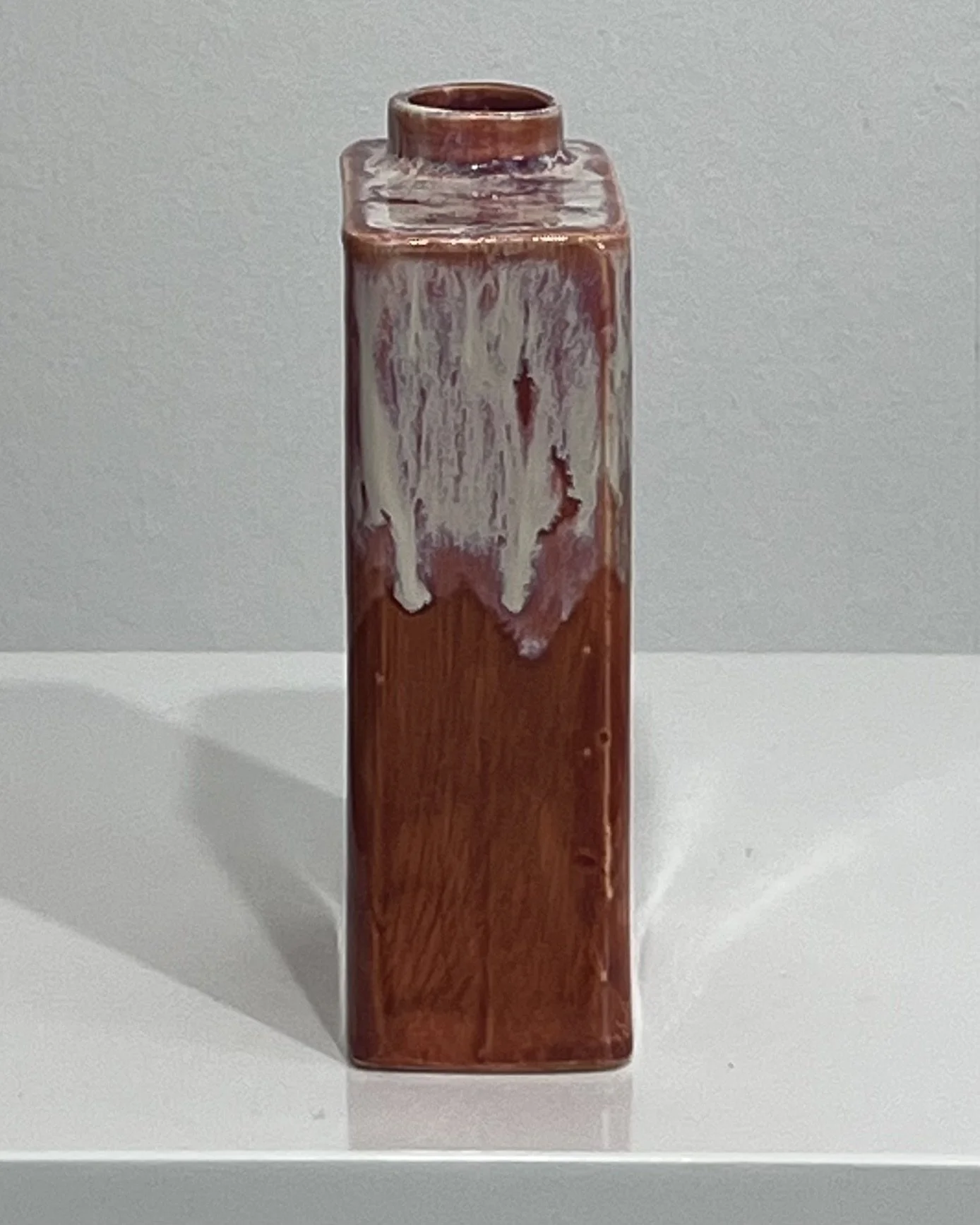 Side view of handbuilt ceramic carton showing layered Chun Plum and Light Flux glaze