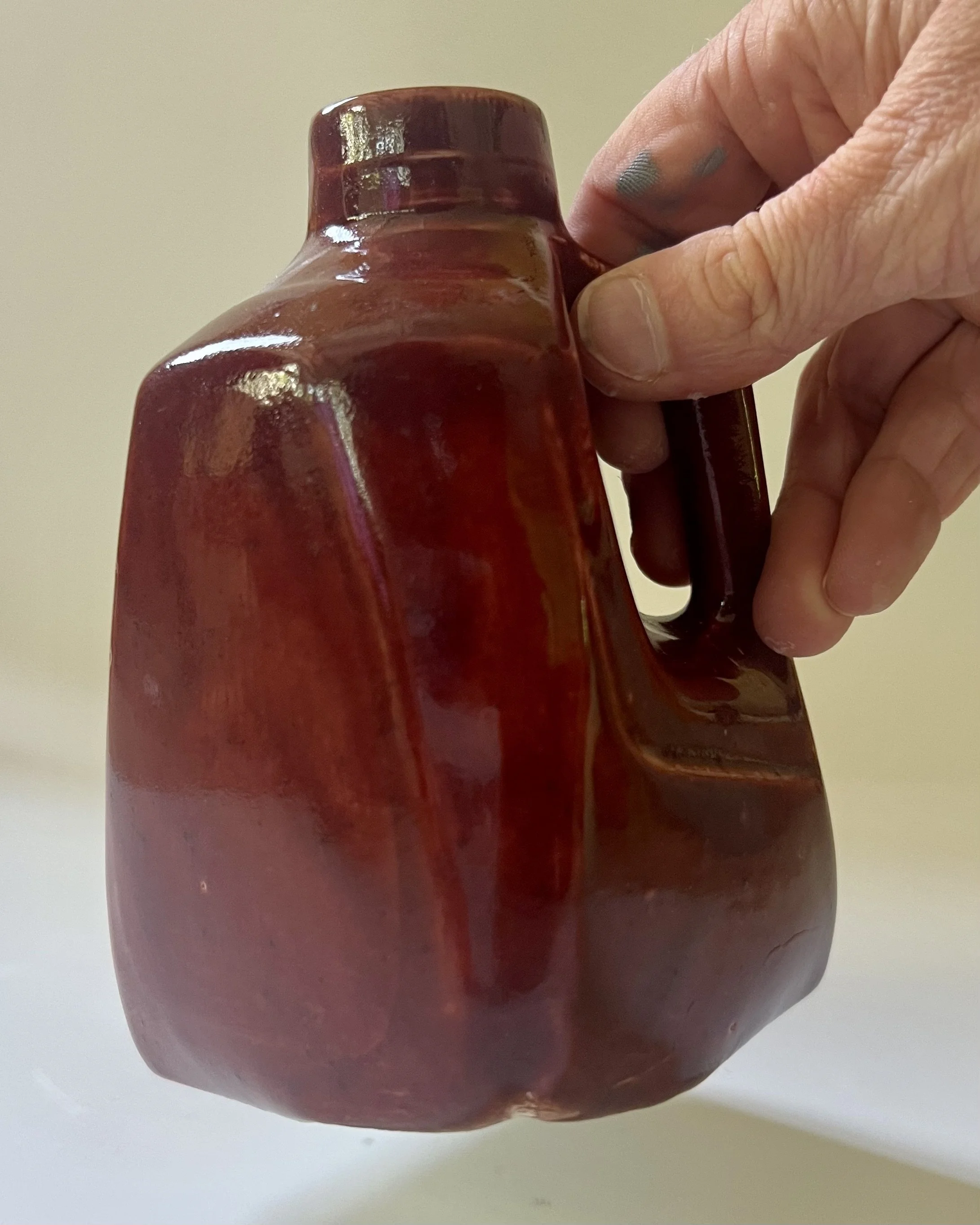 26.51 Deep Firebrick handmade porcelain milk jug vase shown in hand for scale