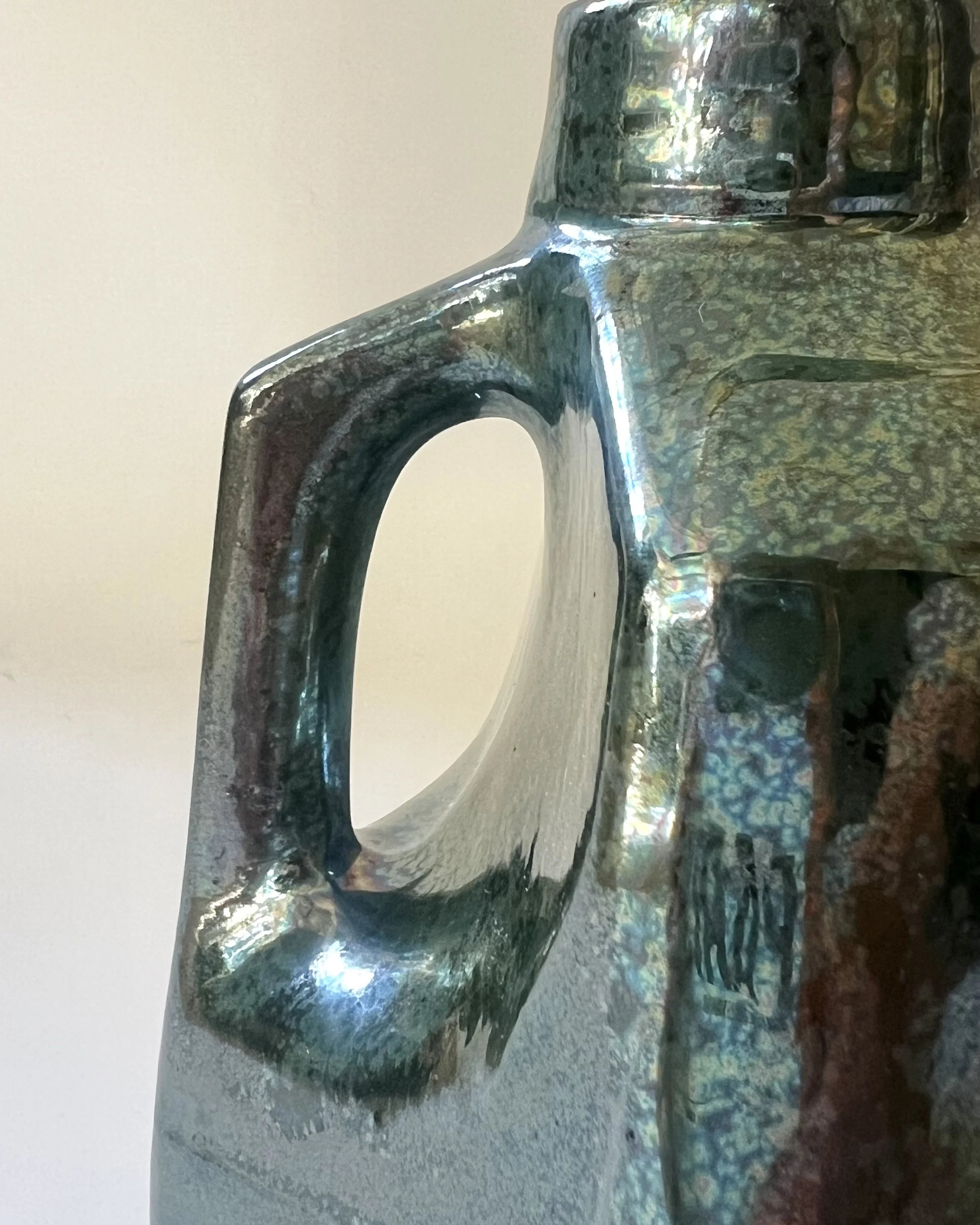 Close-up detail of the handle and shoulder of porcelain milk jug 26.48 in Junebug glaze.