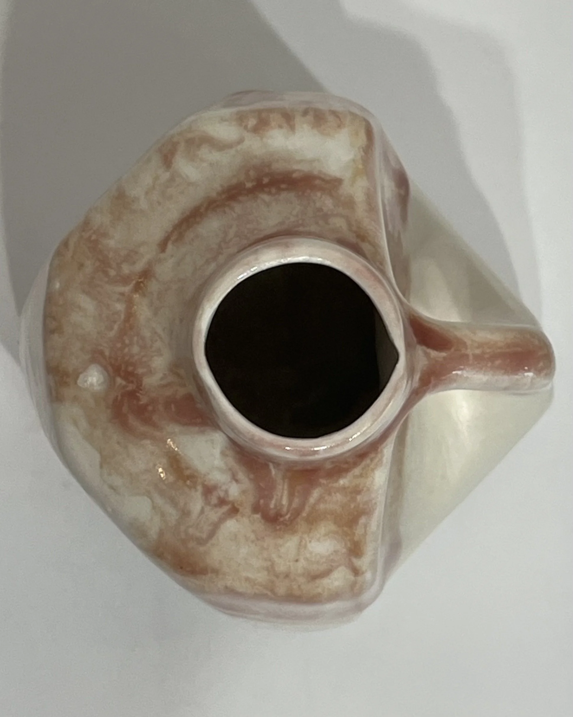 Top view of porcelain jug showing circular opening and layered glaze around rim