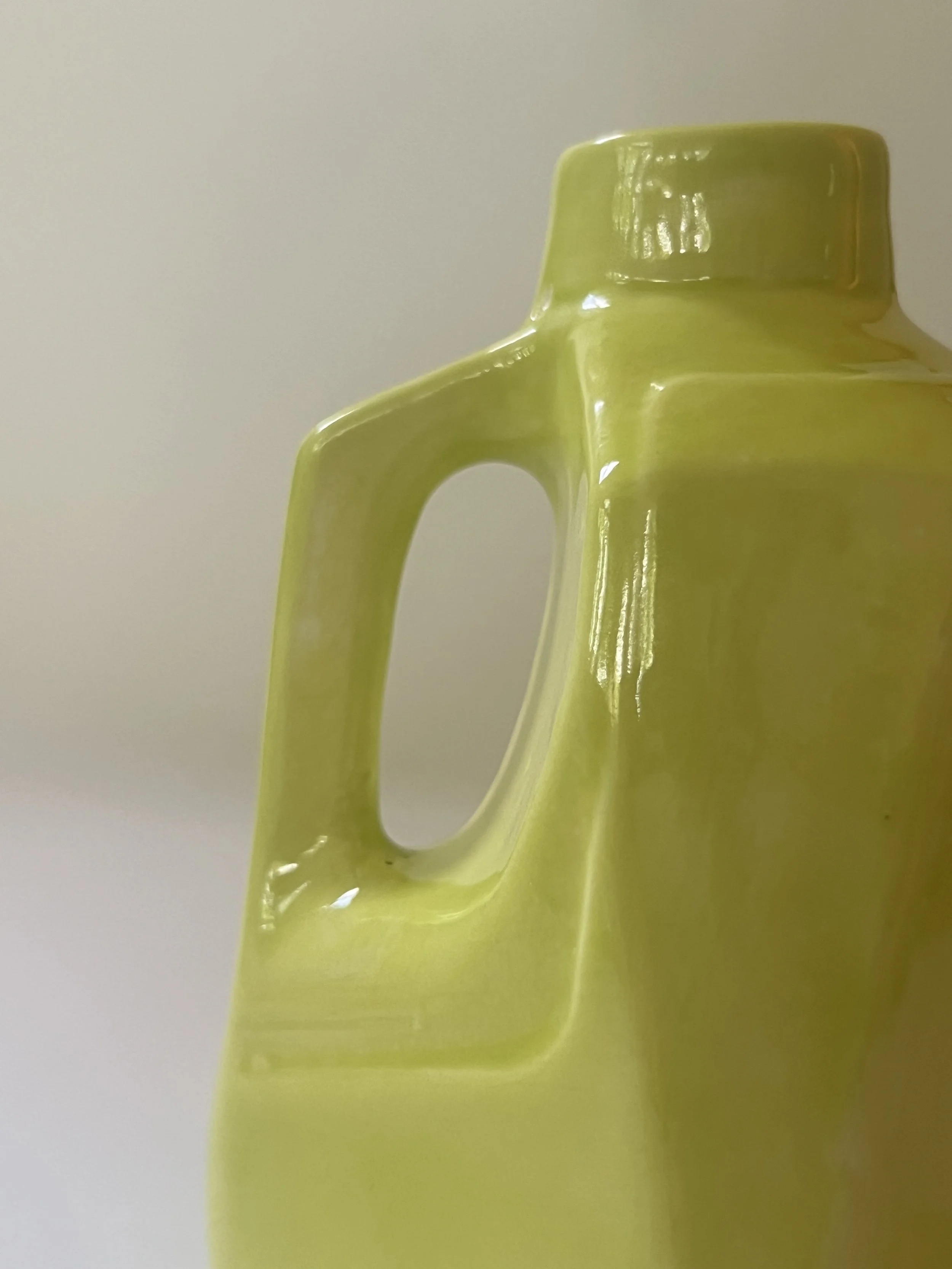 Sculptural angled view of handmade ceramic jug with reflective Pear glaze surface.