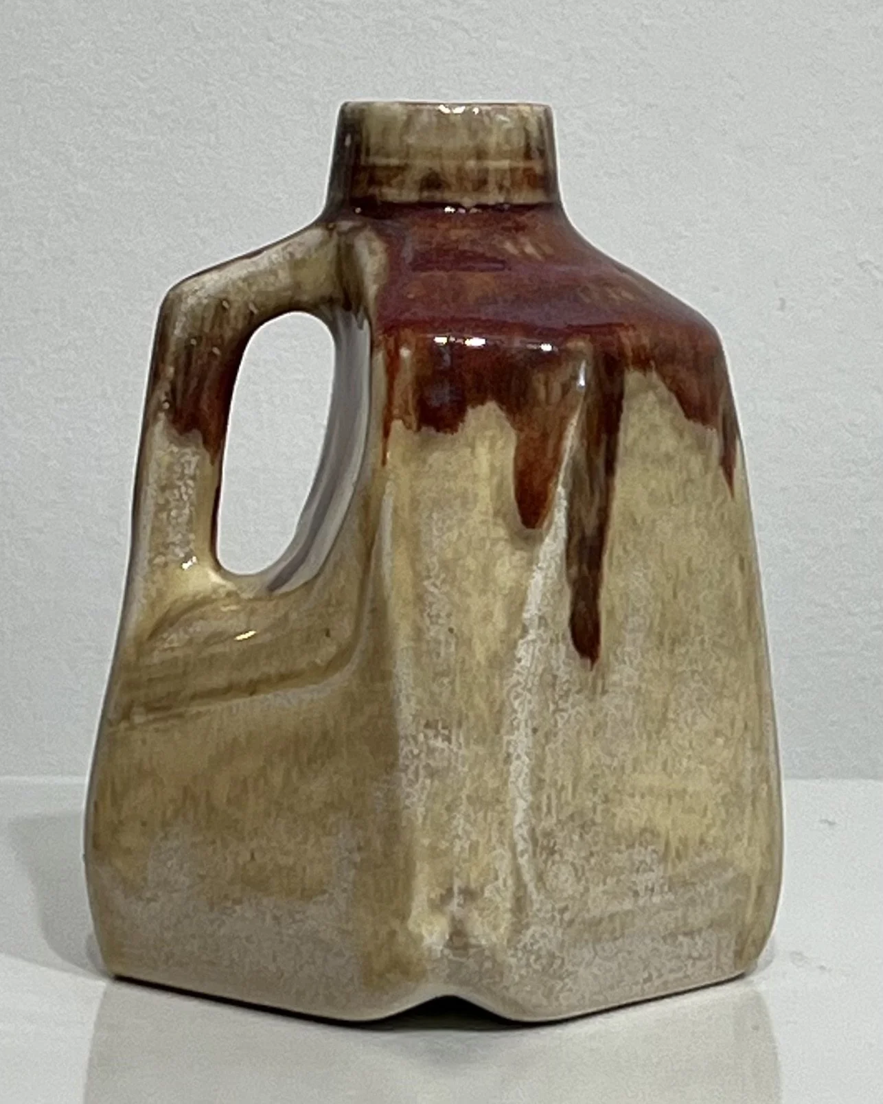 Back view of Oatmeal and Chun Plum ceramic milk jug with cream body and burgundy accents