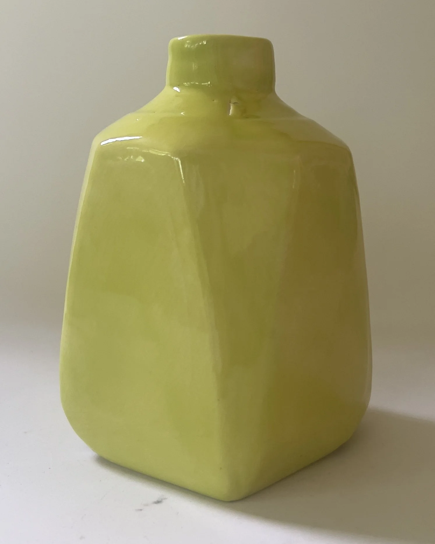 Side view of sculptural ceramic jug highlighting integrated handle and glossy Pear glaze.