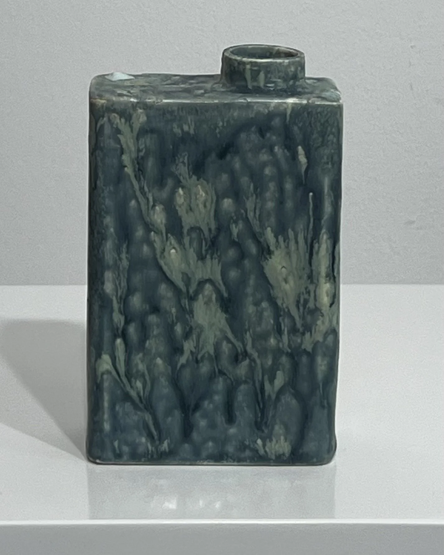 Back view of porcelain Carton vessel showing mottled, weathered-looking ceramic glaze variations.