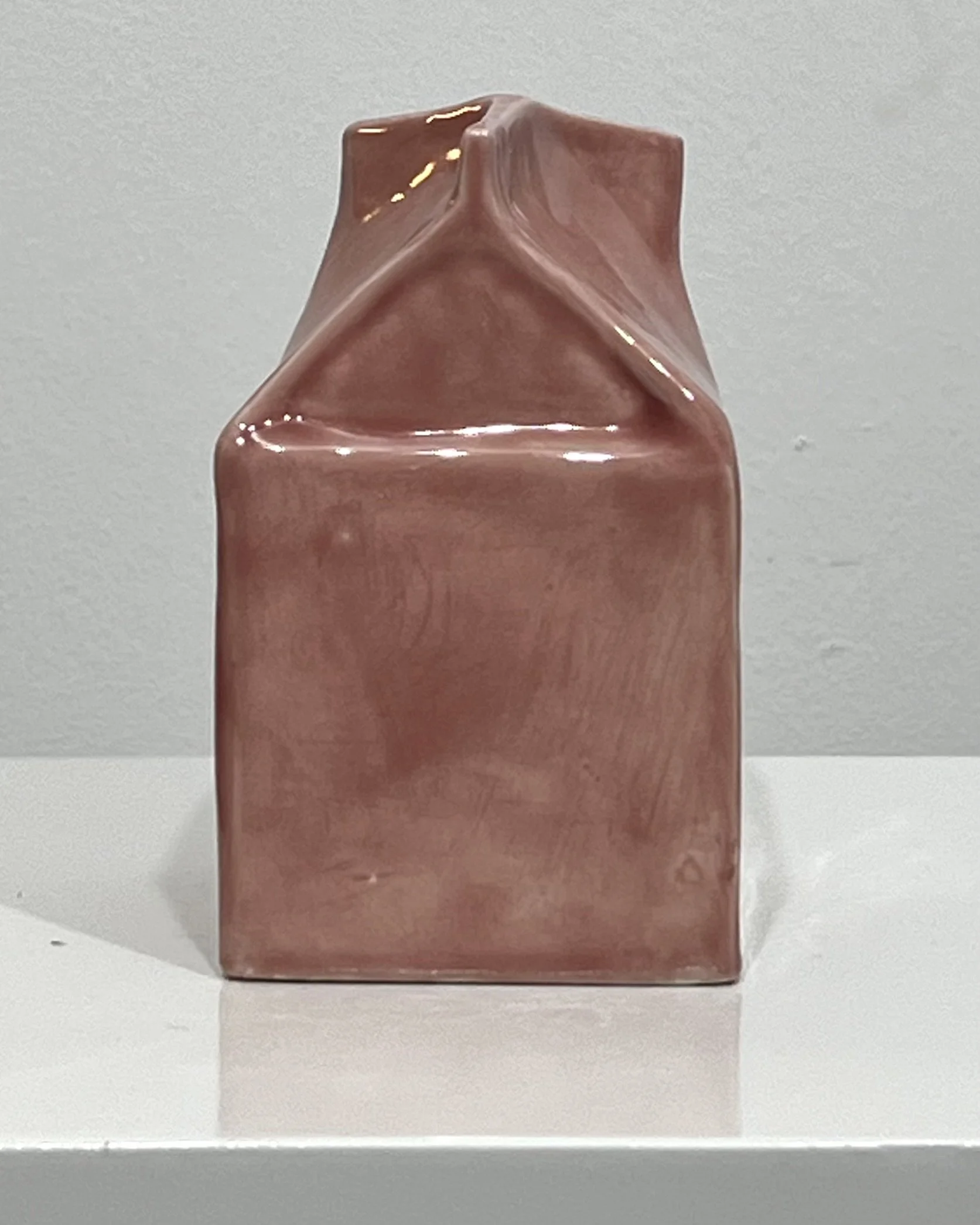 Rear gable view of blush porcelain milk carton sculpture with architectural folded details and glossy glaze finish.