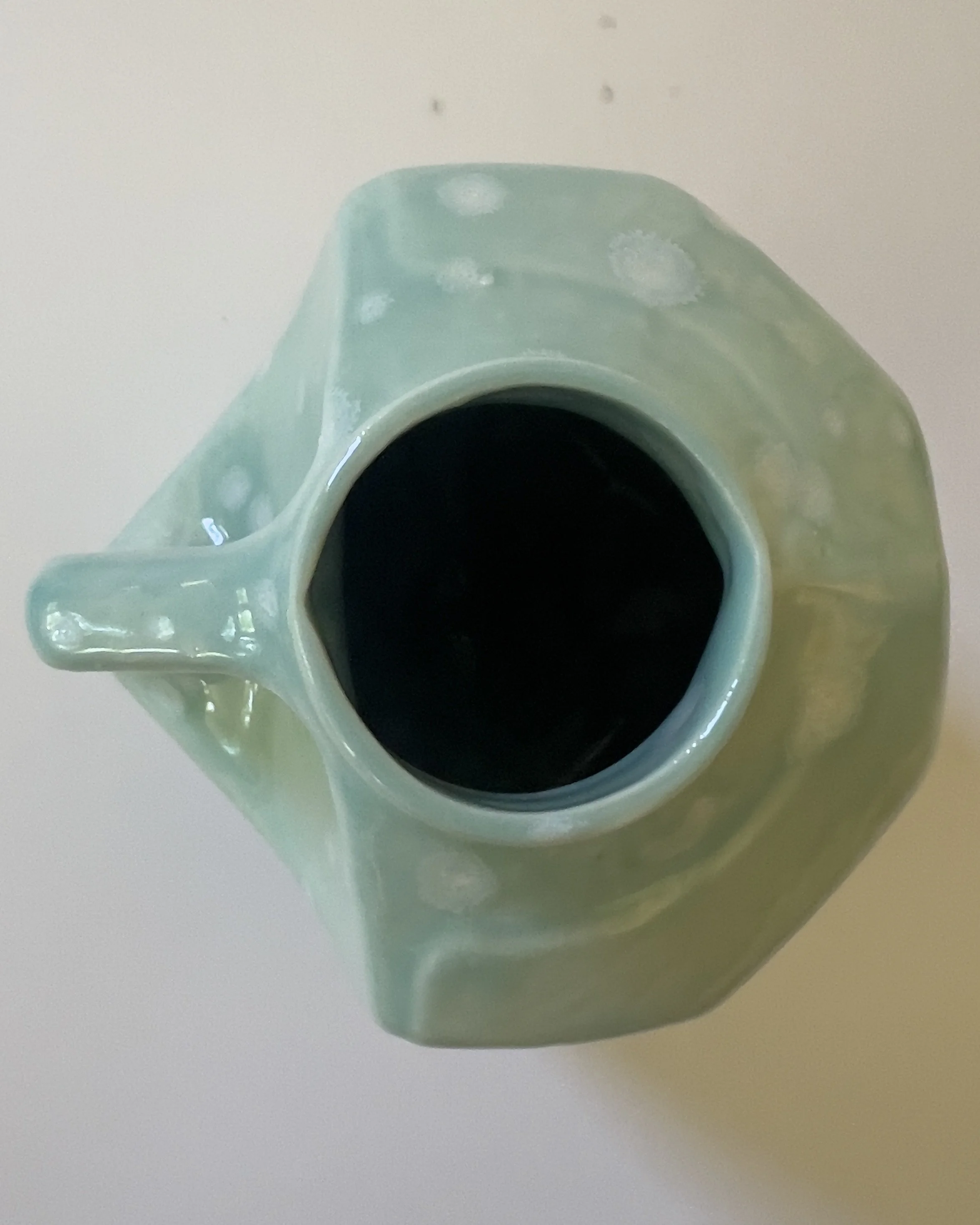 Top view of handmade ceramic milk jug sculpture with narrow opening