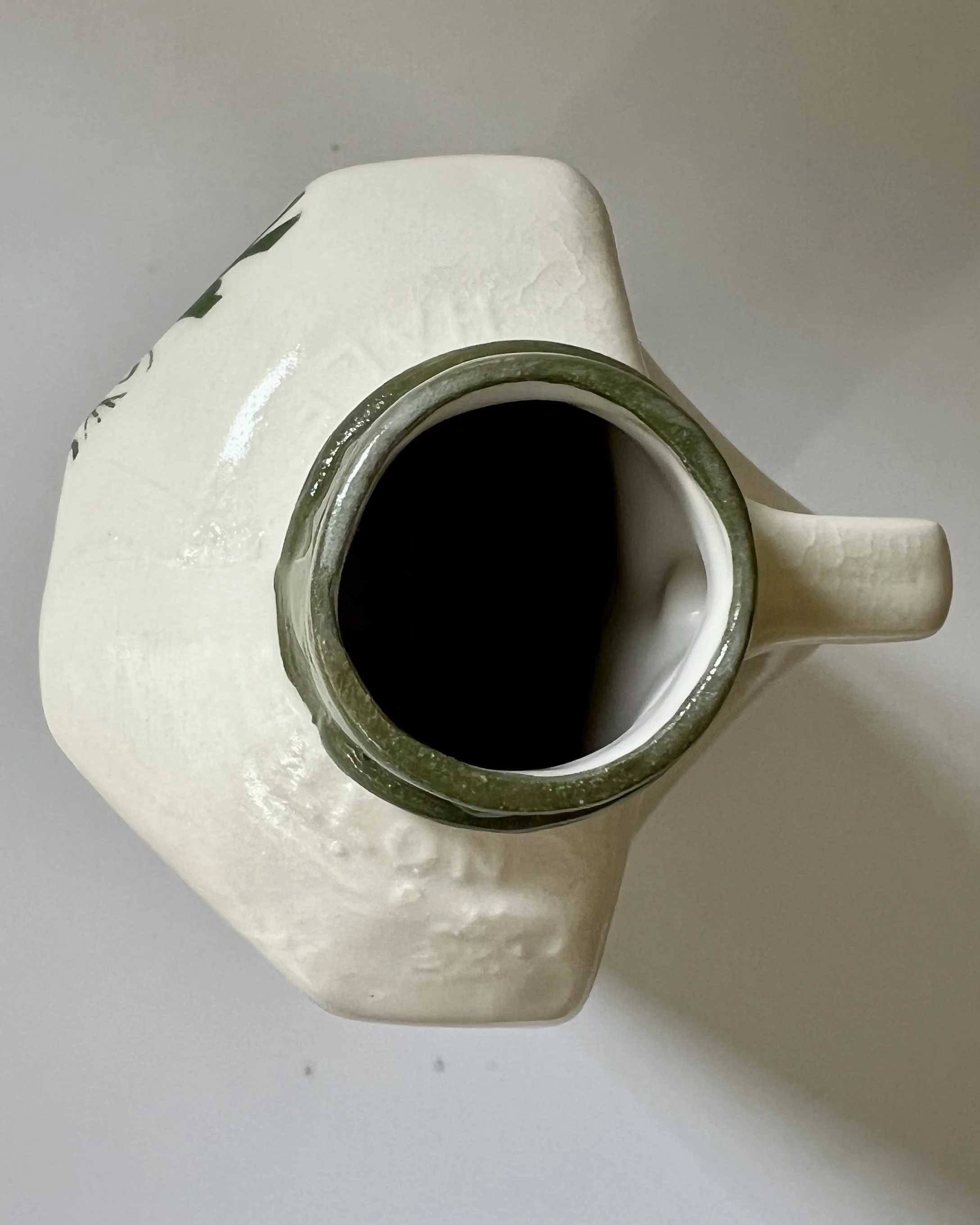 Top view of a handcrafted botanical tall porcelain milk jug showing the porcelain opening and interior.