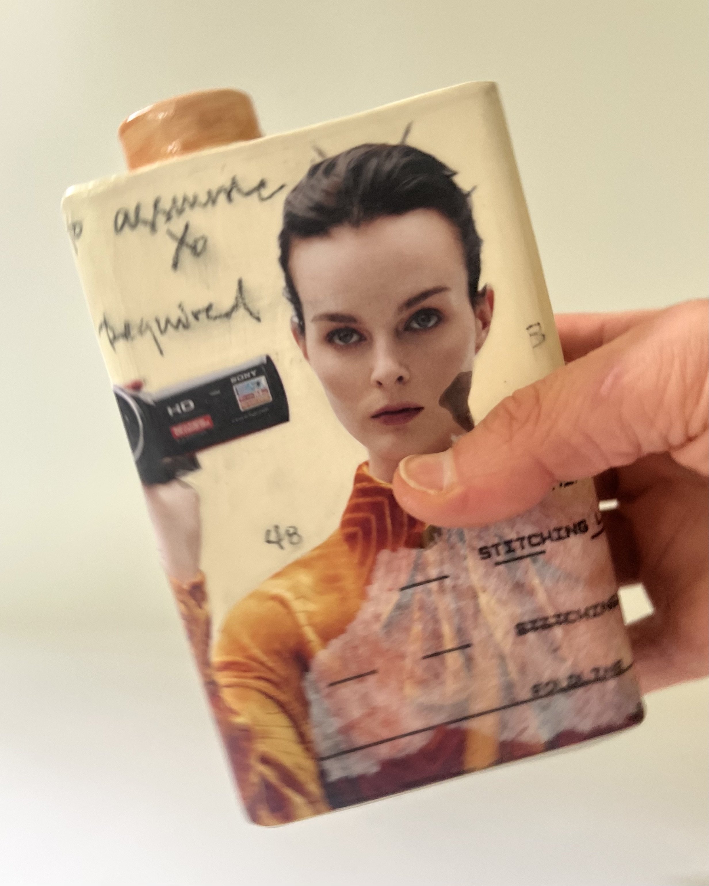 Some Assembly Required porcelain Art Carton shown in hand for scale, handmade by Asheville artist Alissa Van Atta.