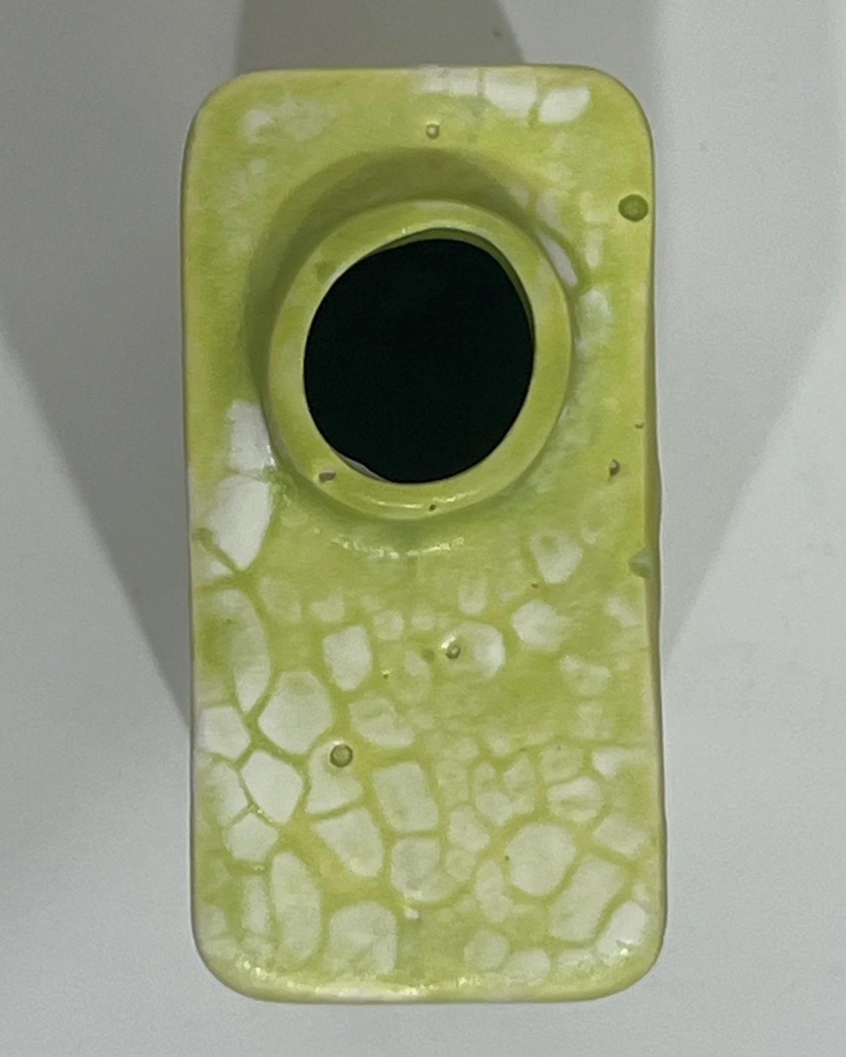 Top view of handmade porcelain Carton vessel showing its circular opening and chartreuse glazed rim.