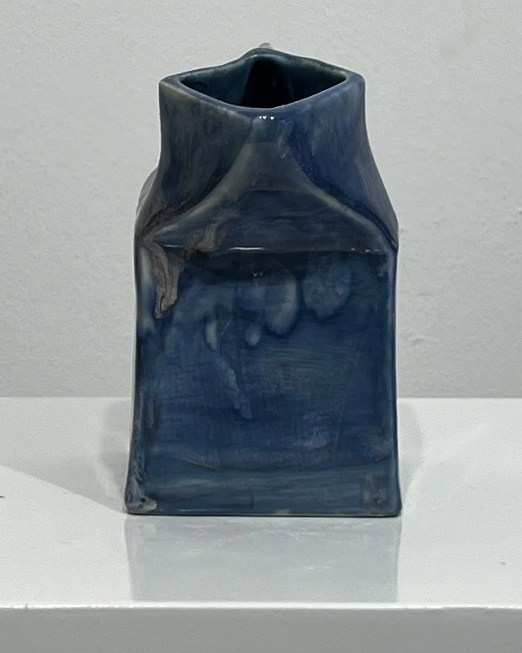 Alternate side view of Blue Splatter porcelain milk carton vessel showing glaze pooling, drips, and tonal shifts in blue.