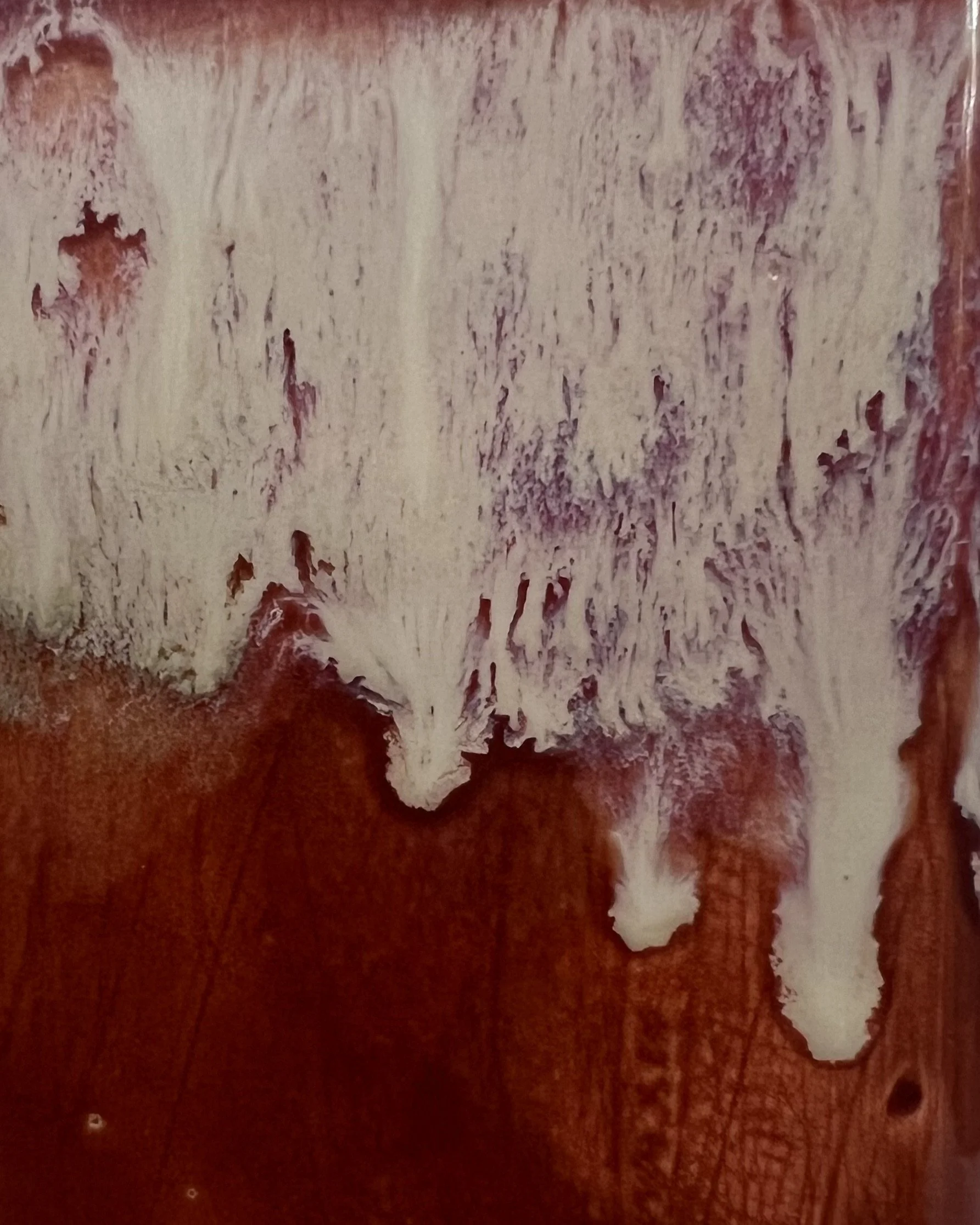 Close-up of Chun Plum and Light Flux glaze showing cream, blush and plum drips over rust red
