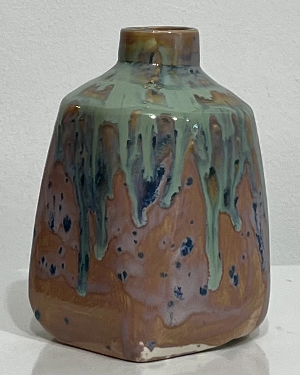 Side view of sculptural ceramic milk jug showing integrated handle and layered glazing