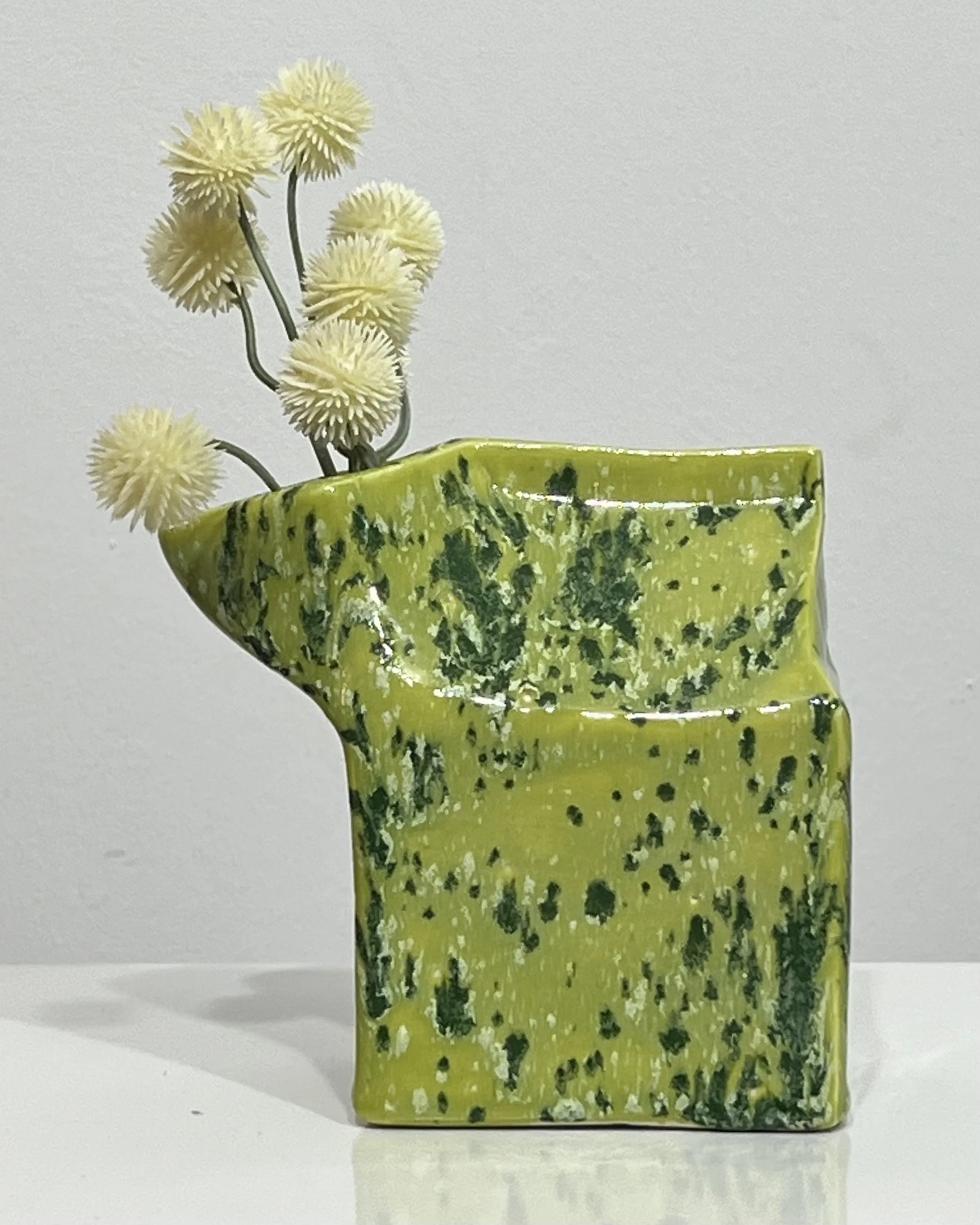 Porcelain milk carton vase displaying flowers, finished in Lime Shower chartreuse glaze.