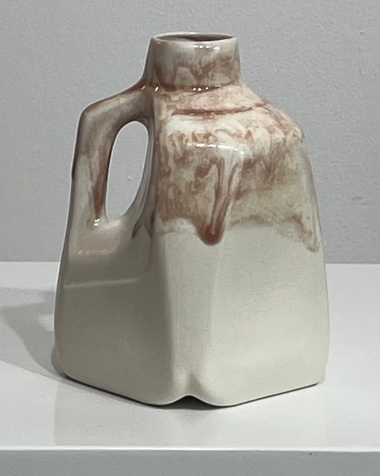 Side view of porcelain jug with handle and layered plum glaze